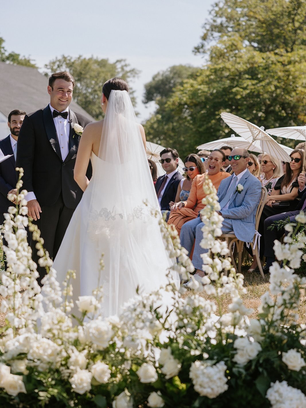 Grace and Collin walked down a pathway of white roses and delphinium, leading to the shimmering water views at the @1774inn.
 
Event Planning &amp; Design: @sheluxewed
Venue: @1774Inn
Photographer: @jillhoylephotography 
Floral Design: @honeysucklewa