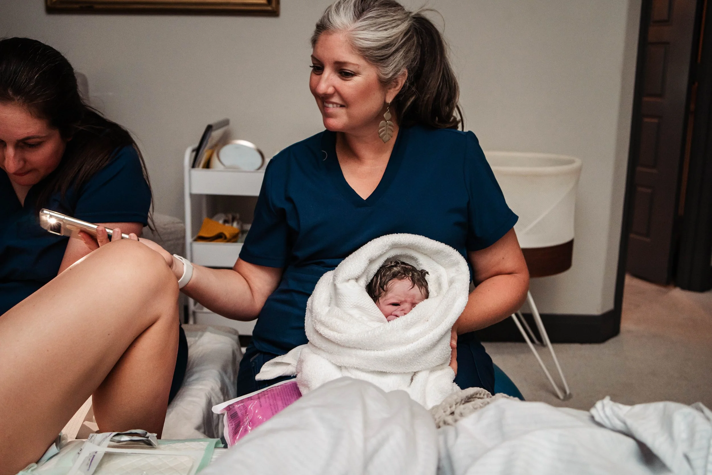 Heather from Living Water Snuggling Baby While Mom has a Tear Repaired