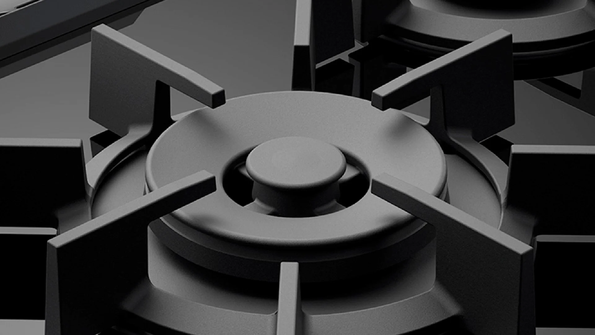 Whirlpool cooking appliance detail showing gas burner geometry, black cooktop surface, metal grates, and premium range design execution.
