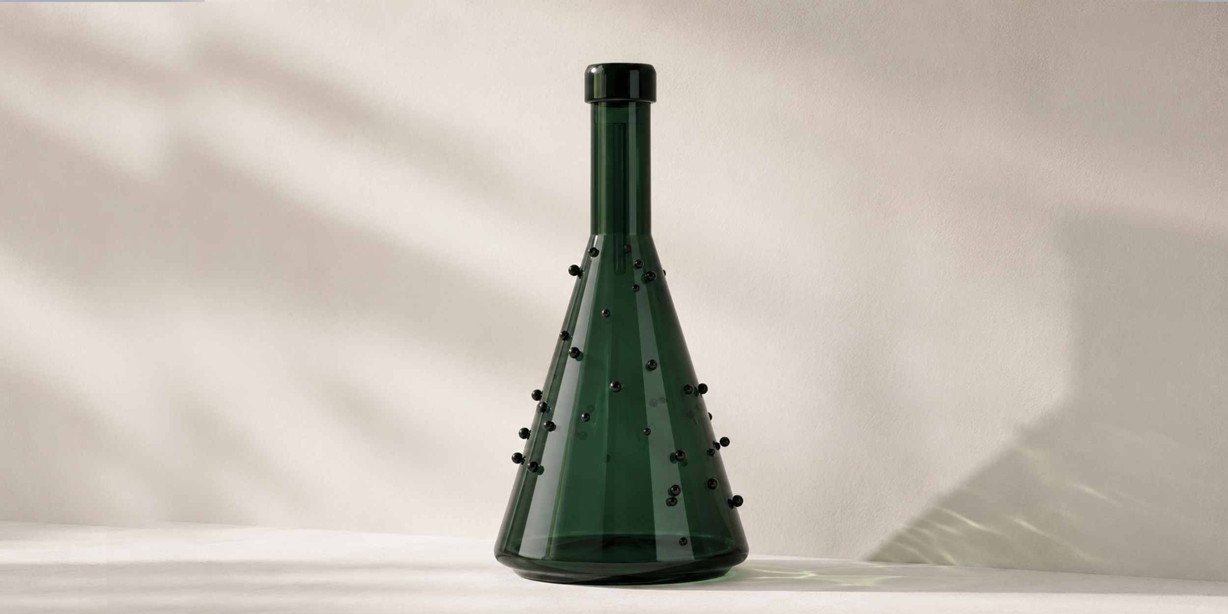 Product design concept showing a green glass bottle with spherical black accents, exploring object identity, material contrast, and decorative interaction.
