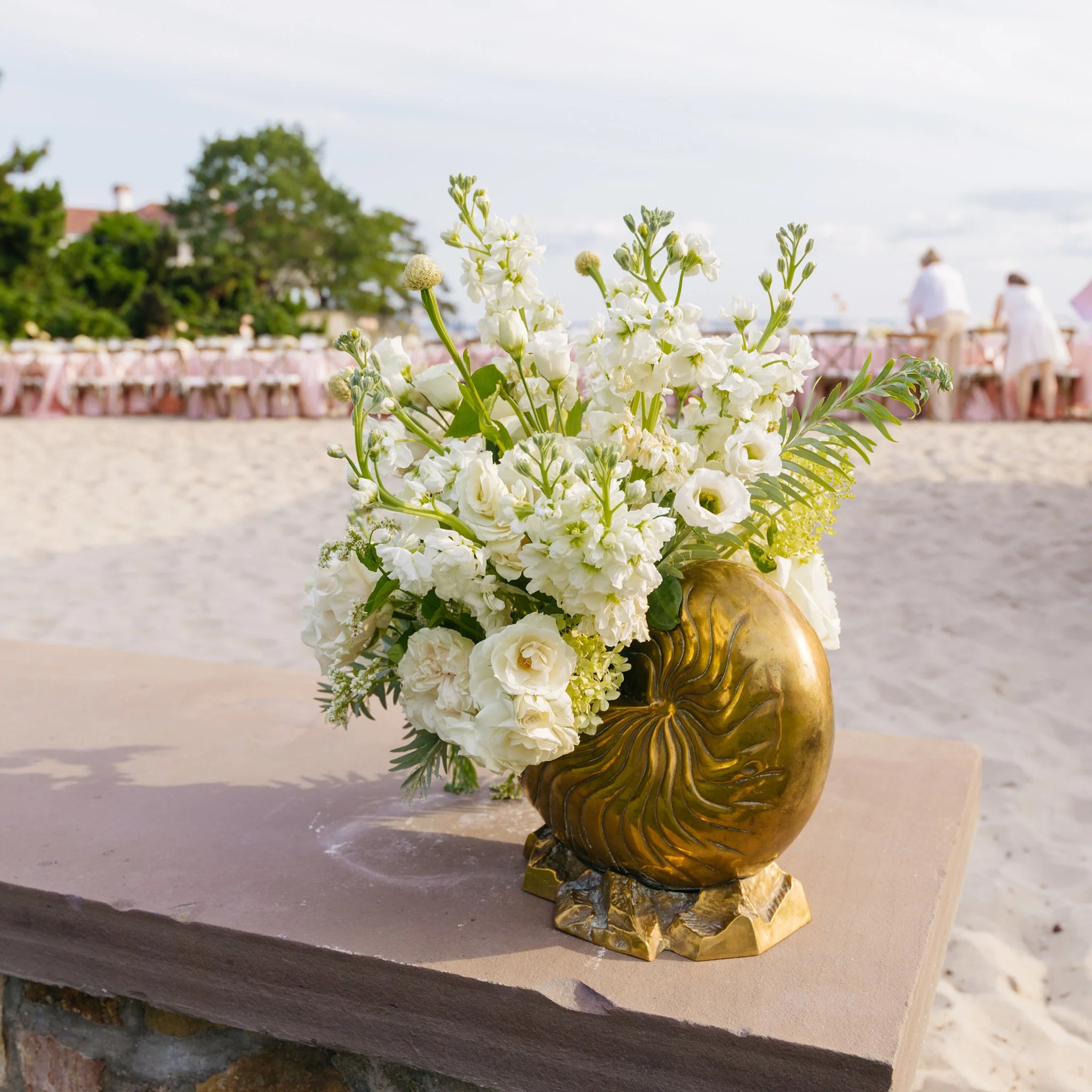 Gold seashell vessels framing the entrance to the tablescape, shipwrecked gilded age bridal shower design