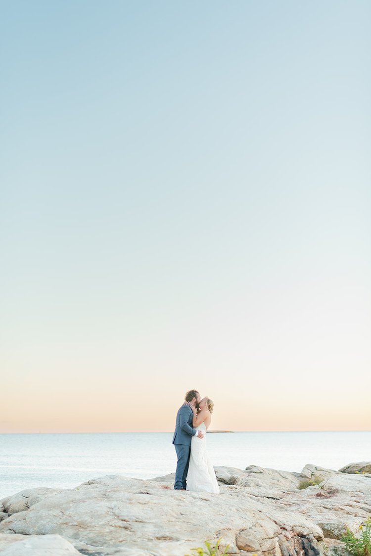 bride+and+groom+kiss+on+the+ocean+at+their+wedding.jpg