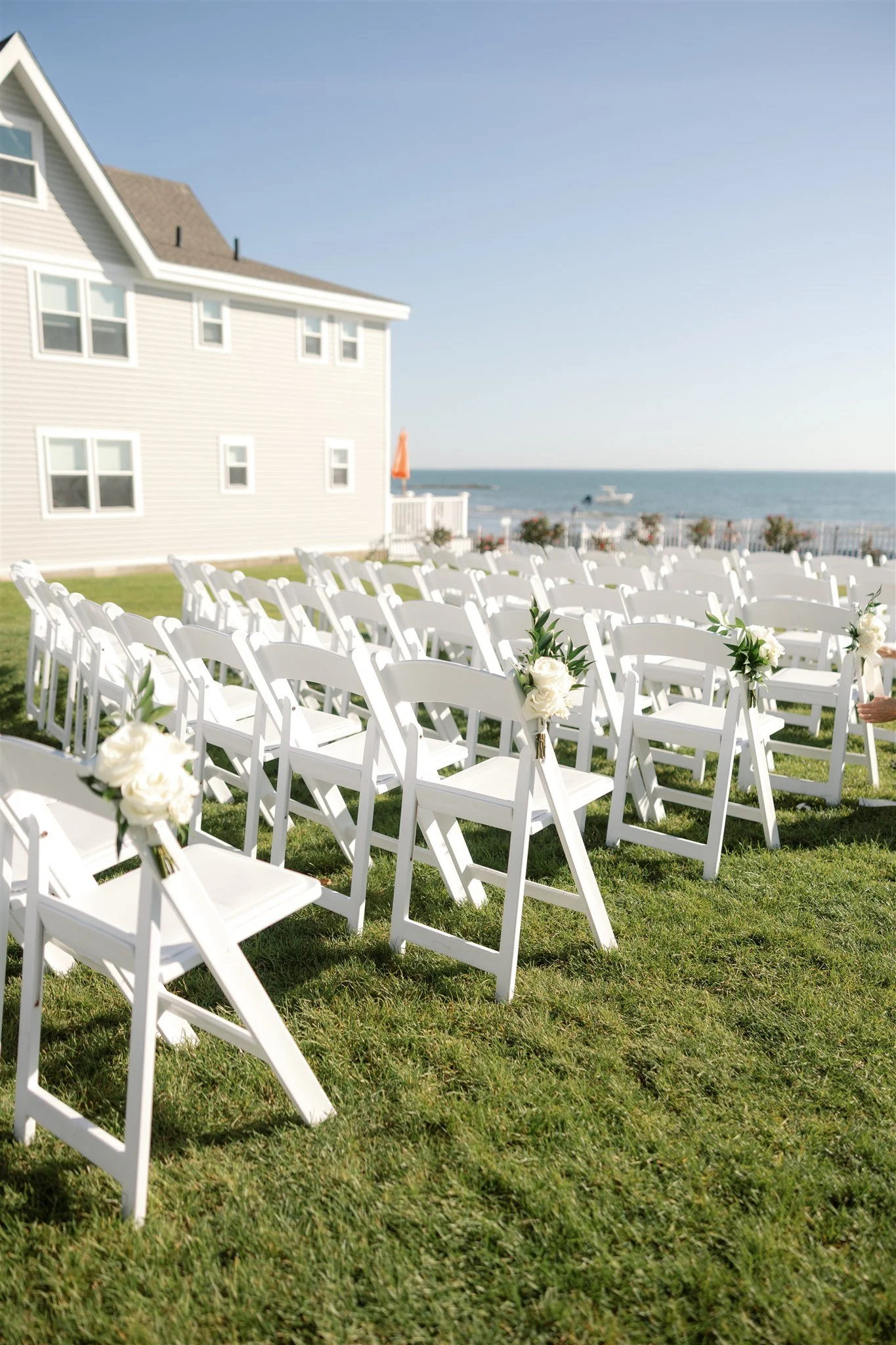 White ceremony florals designed for repurposing into the reception, photographed on the lawn before transition.
