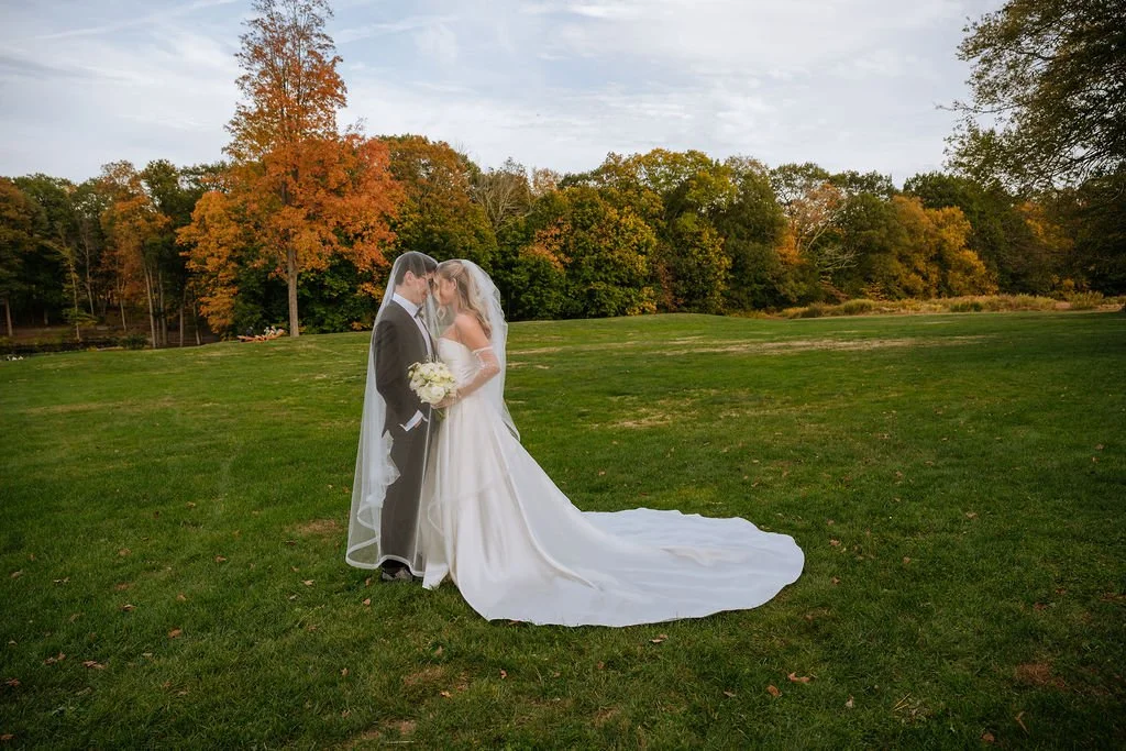 Bride celebrating with groom during fall wedding portraits at Waveny House