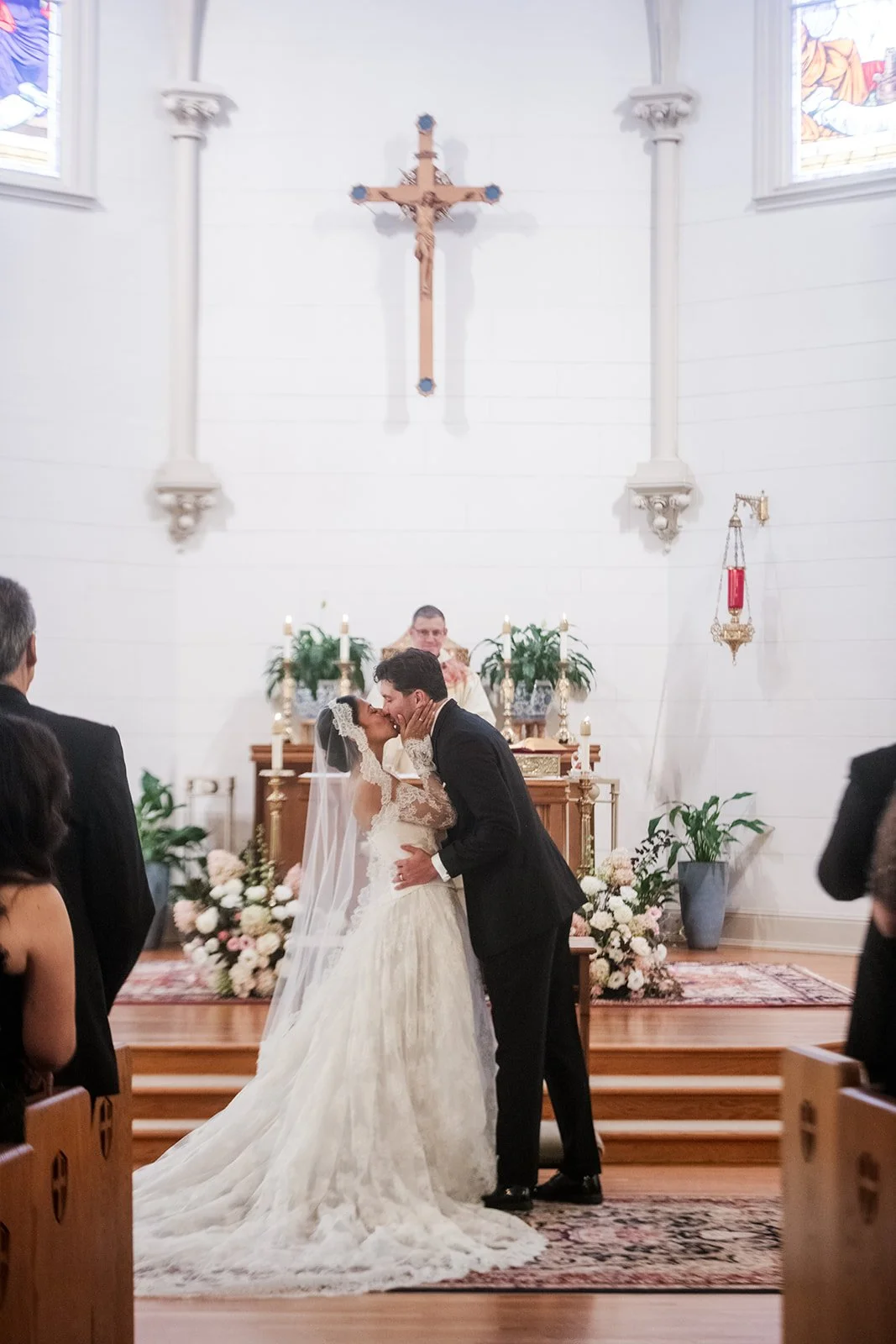 Wedding altar flowers featuring white blooms, plum accents, and local foliage.