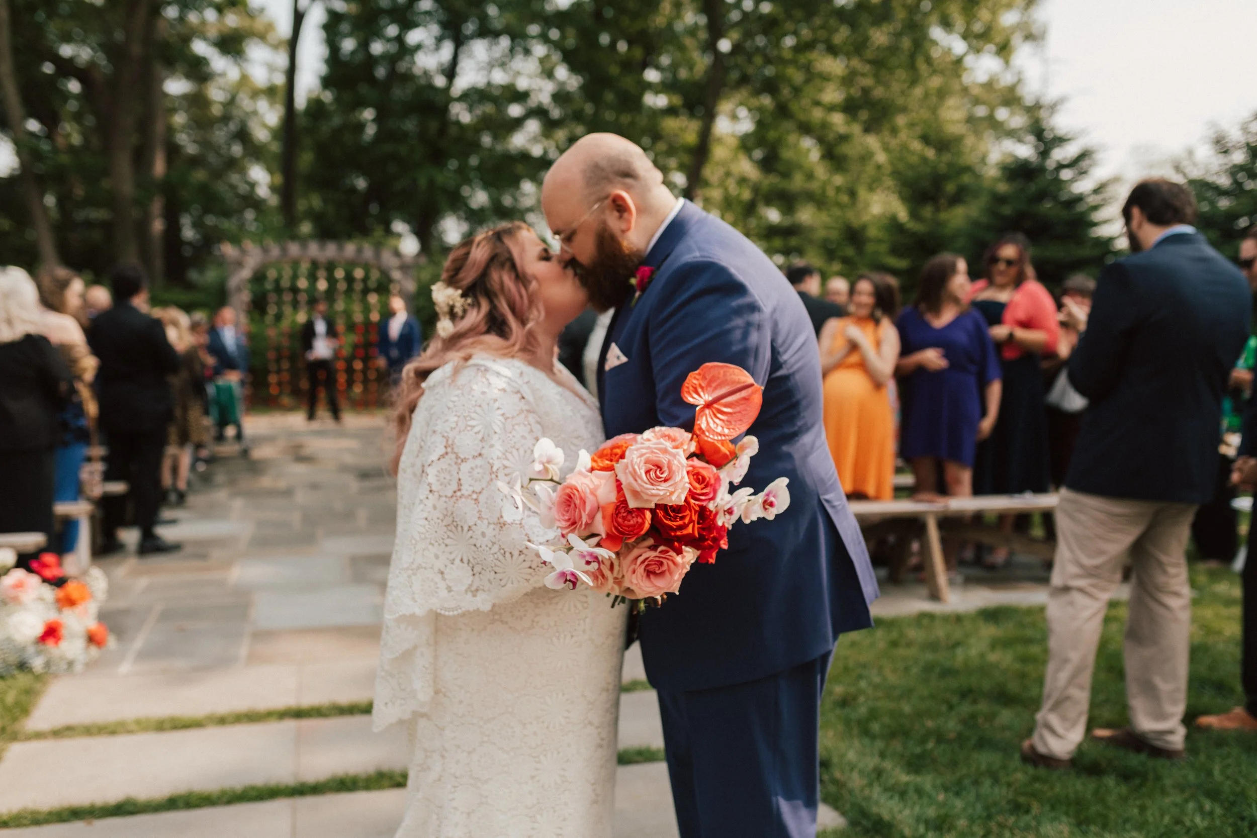 Wedding ceremony florals designed with roses and anthuriums in a high-impact color palette.