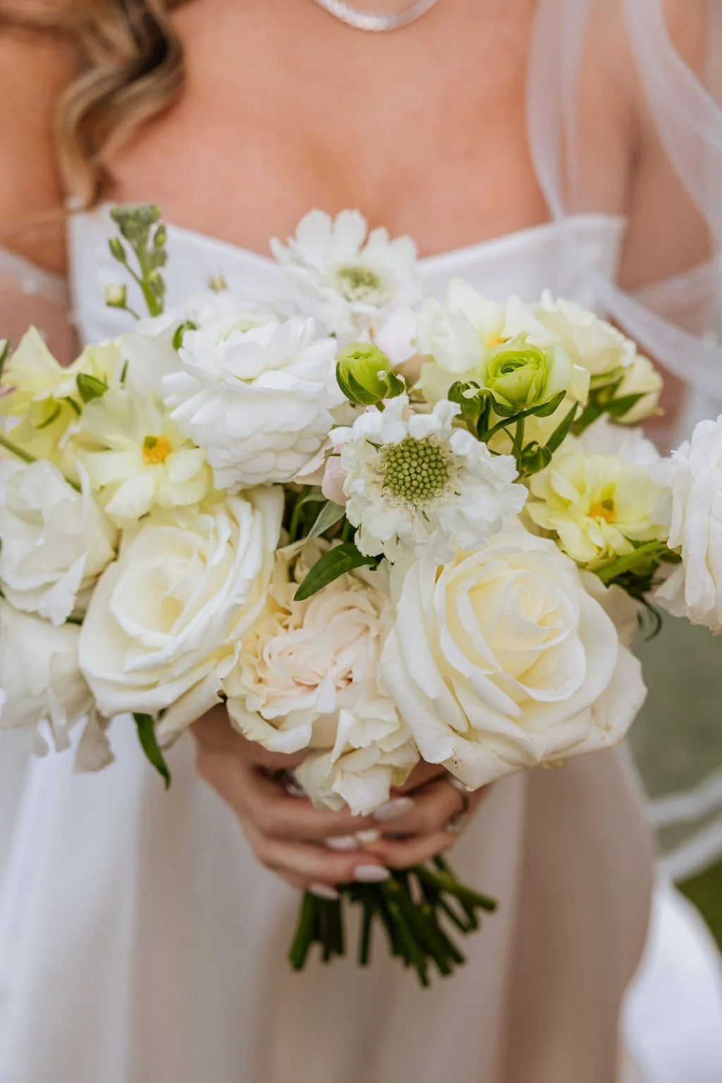 Close up bridal bouquet featuring butterfly ranunculus cottage roses and spray roses