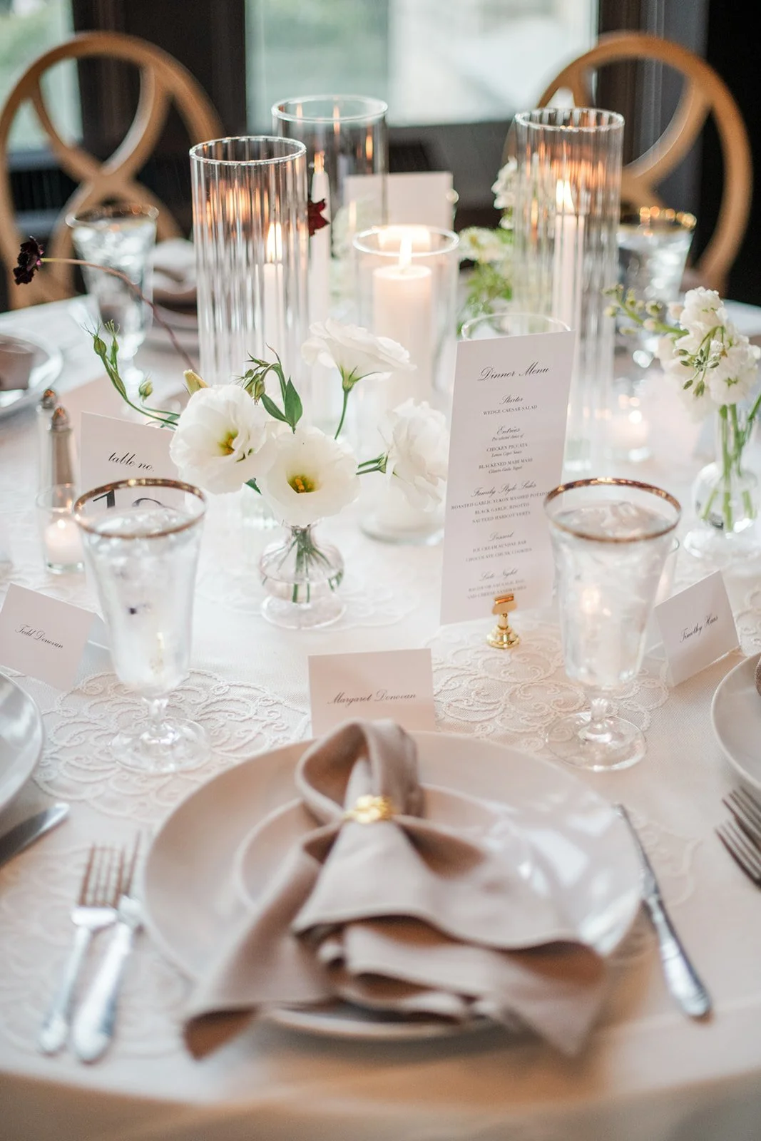 Candlelit tablescape with bud vase centerpieces and gentle plum accents.