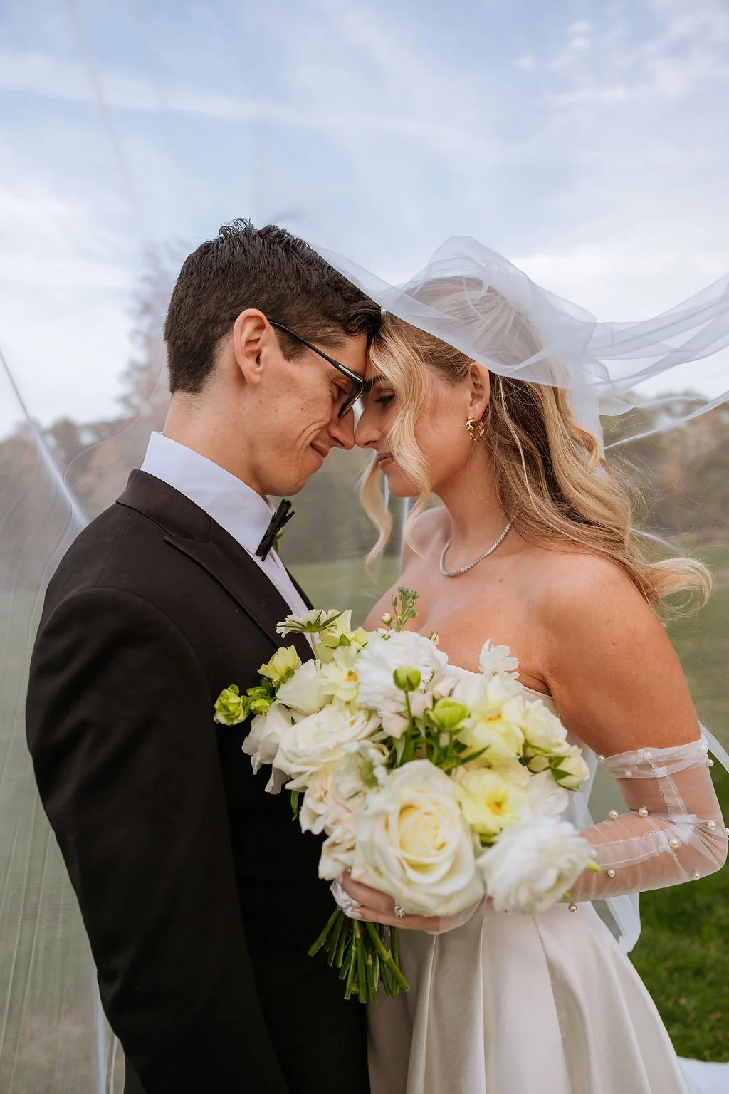 Soft neutral bridal bouquet featuring spray roses, cottage roses, butterfly ranunculus, and heather with ivory ribbon — Connecticut wedding florals by First Blush Weddings.
