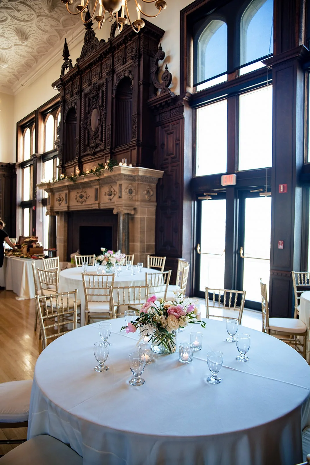 Natural, airy low centerpiece of white and blush blossoms with reaching green branches in a gold compote at Branford House