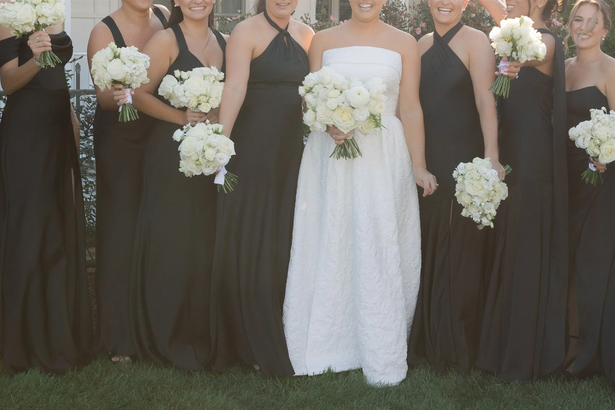 Bridesmaid holding a simple white garden rose bouquet with soft textural accents.