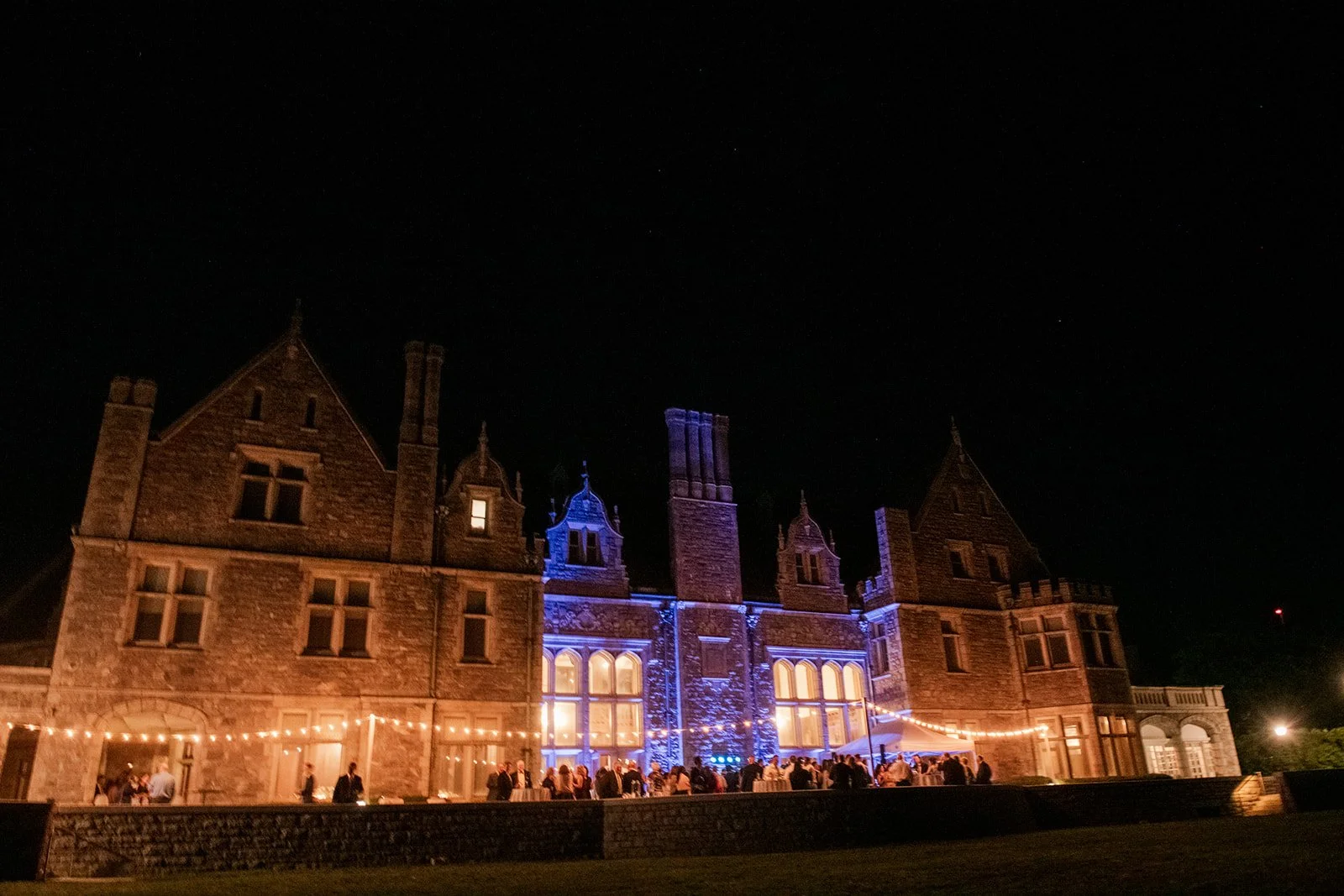 Evening wedding dancing on the outdoor patio at Branford House with coastal Connecticut views