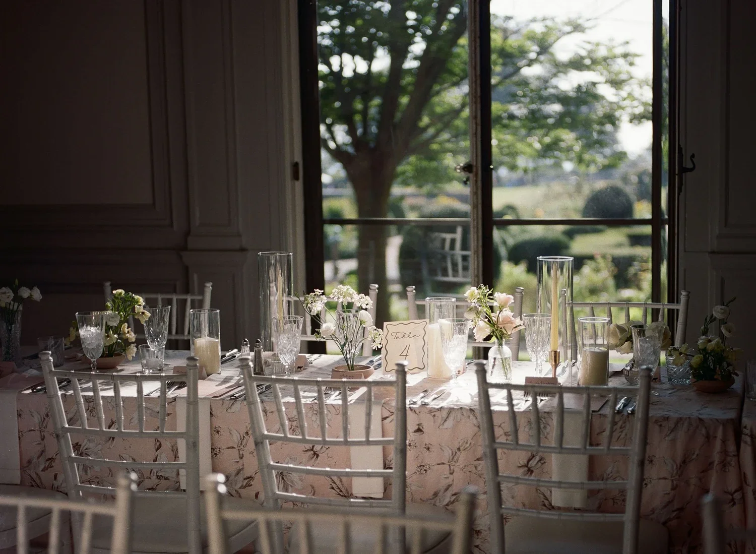 Candlelit long tables with garden-style floral centerpieces inside the mansion at Eolia Mansion