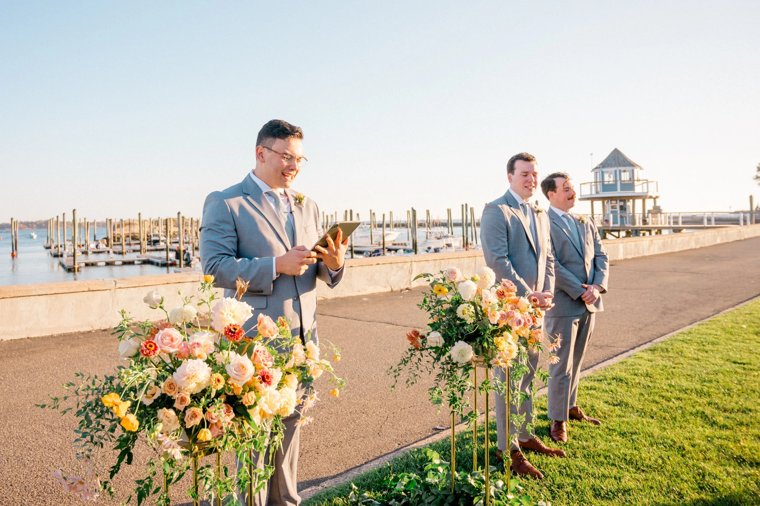 Statement ceremony arrangements with dahlias, zinnias, and roses in fall palette.