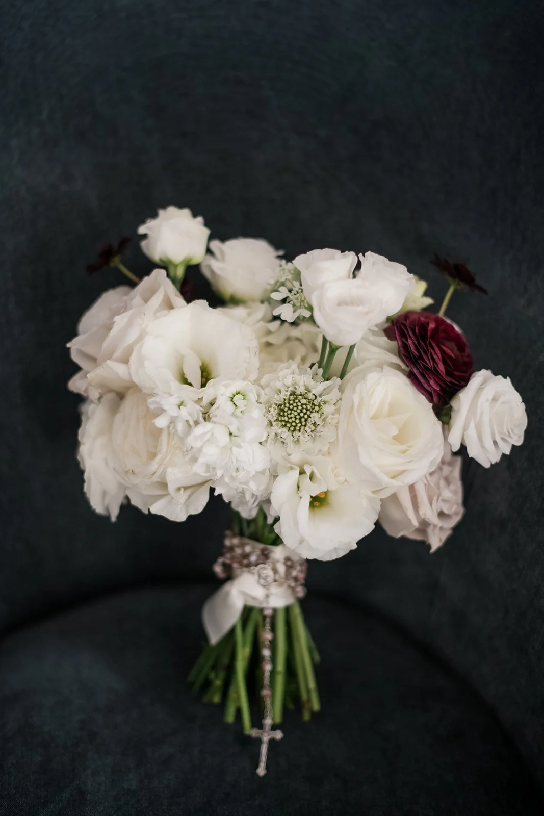 Luxury bridal bouquet featuring textural white florals and soft mauve undertones.