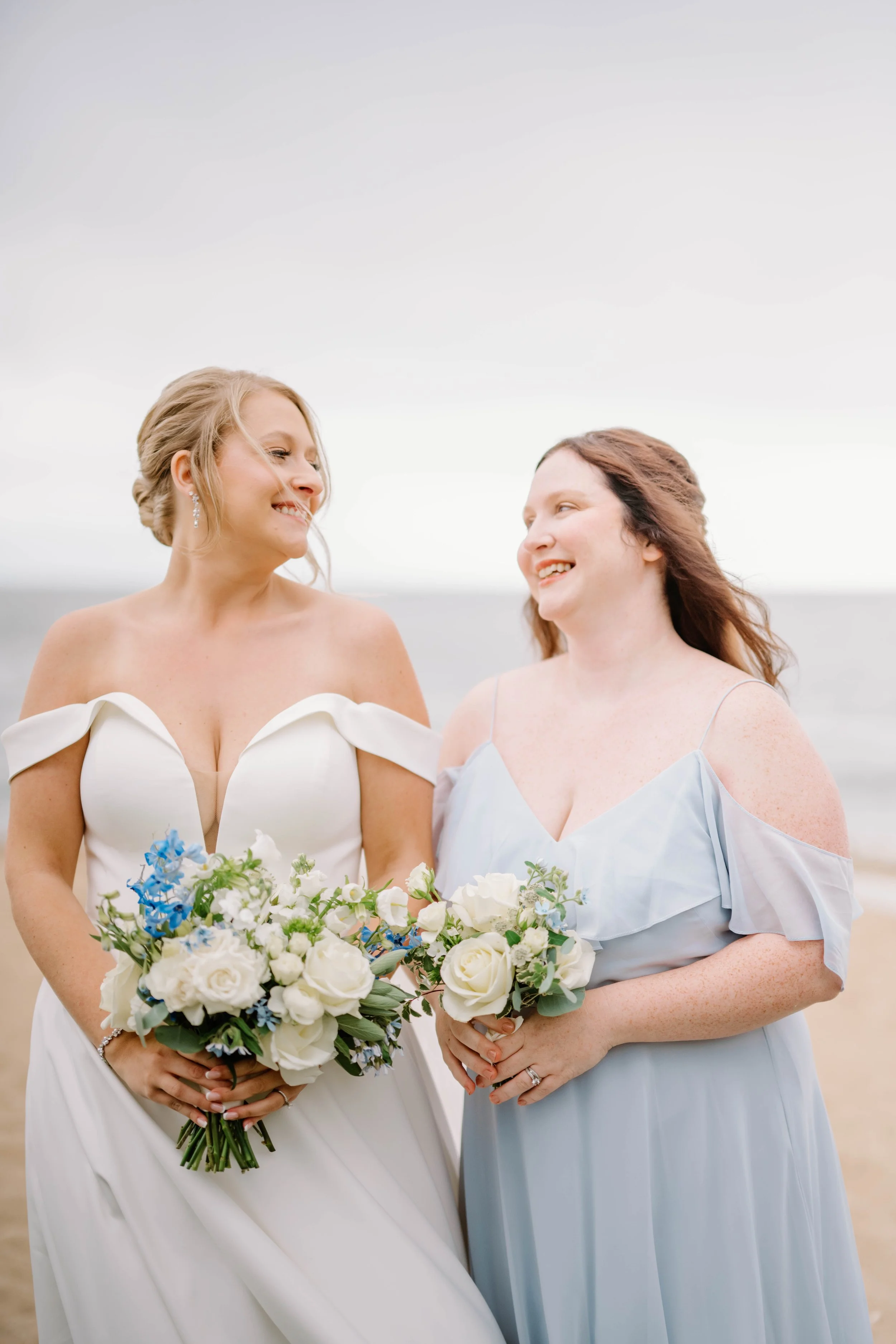 Bridal bouquet of white roses and hydrangea held against ocean view at Madison Beach Hotel wedding.