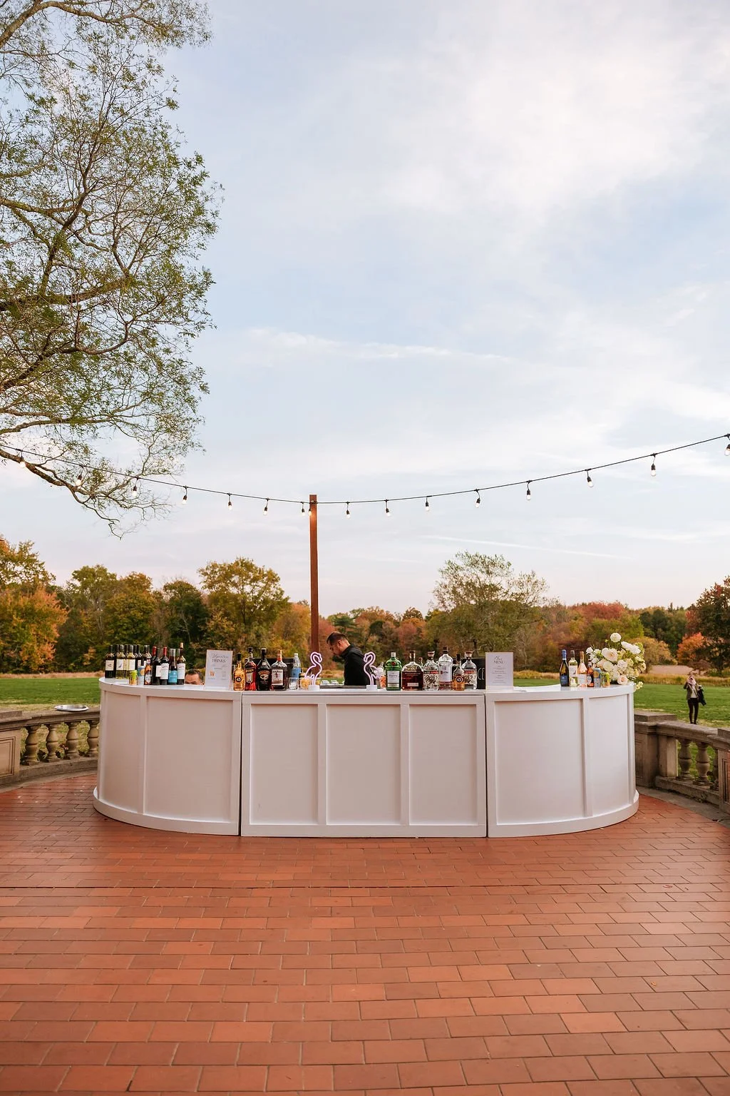 Bar floral installation with neutral blooms at outdoor wedding cocktail hour