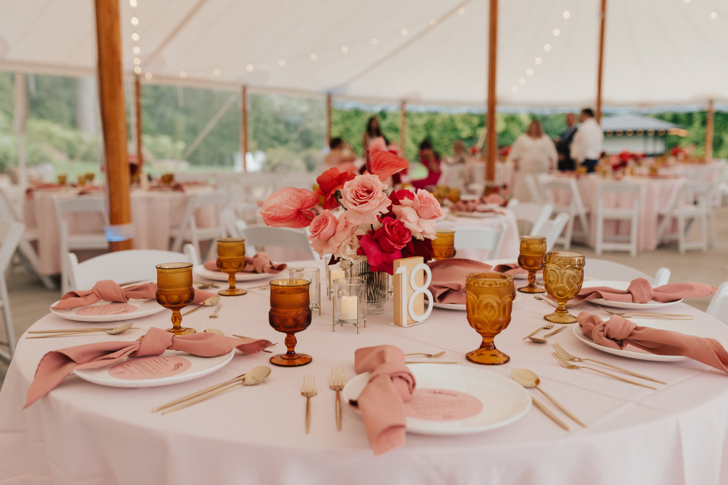 Wedding reception centerpieces at The Garden at The Hops featuring bold florals and warm candlelight.