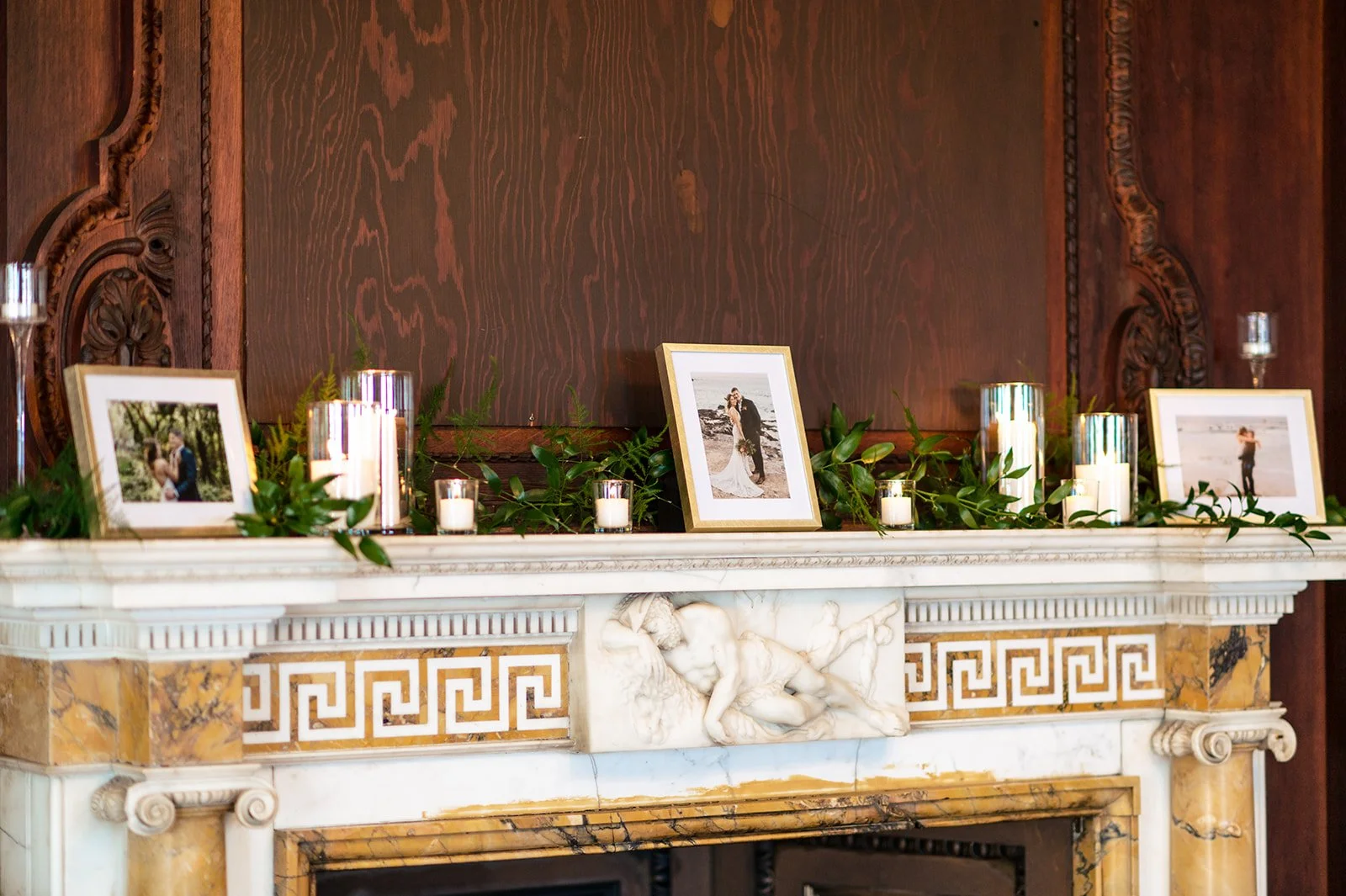 Branford House fireplace mantel draped with smilax and asparagus fern garland, pillar candles in glass cylinders and votives
