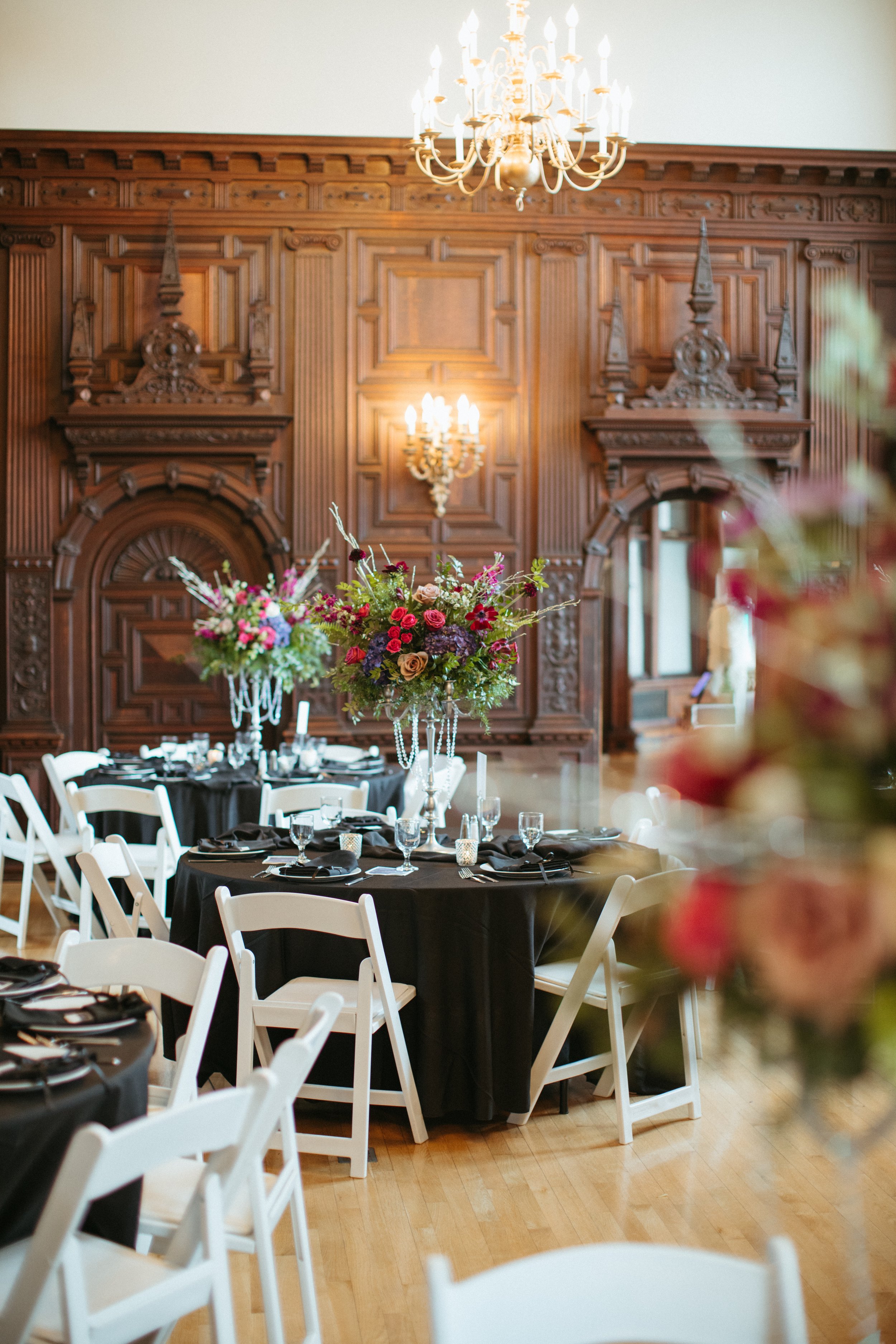 Candlelit wedding reception tables with moody florals at Branford House