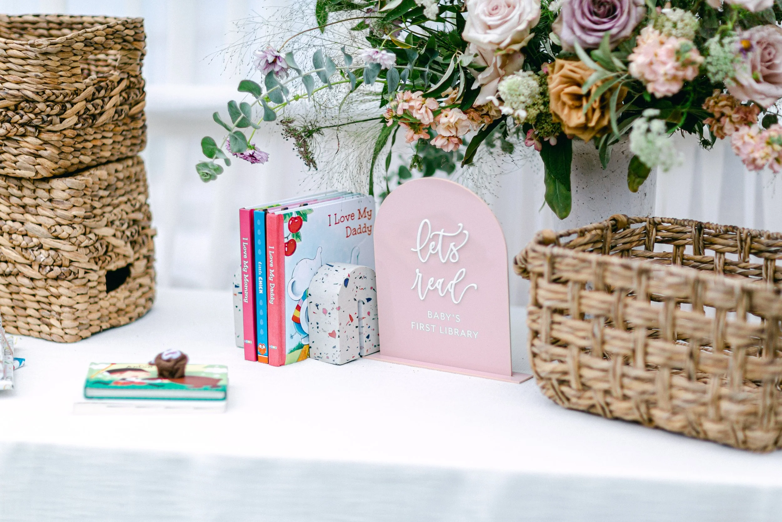 Earth-toned baby shower flowers with mocha roses and neutral foliage on gift table