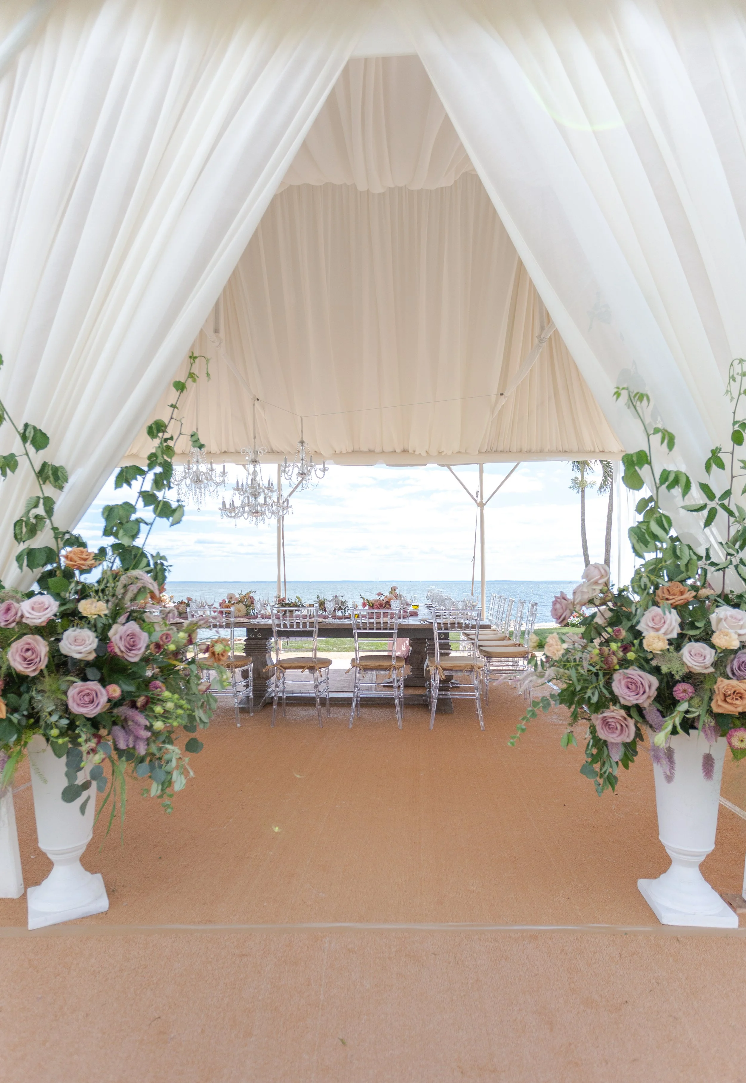 Tall floral columns marking the entrance to a baby shower tent