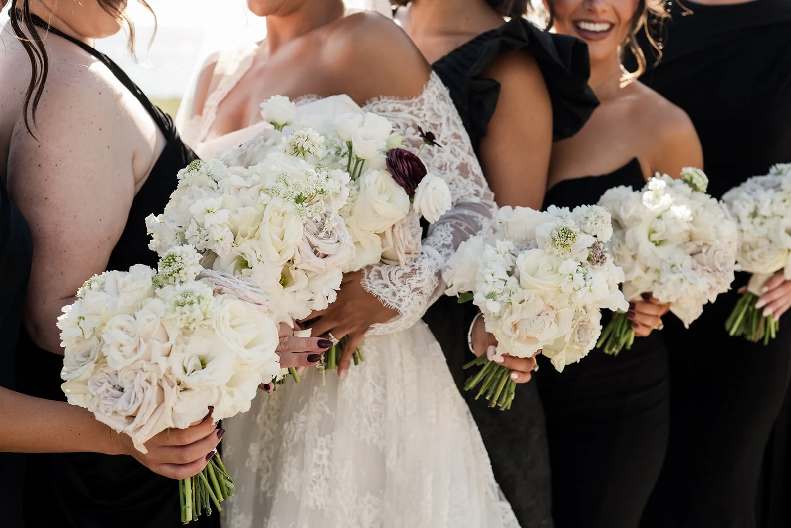 Elegant bridal party flowers in a neutral palette with ivory ribbon accents.