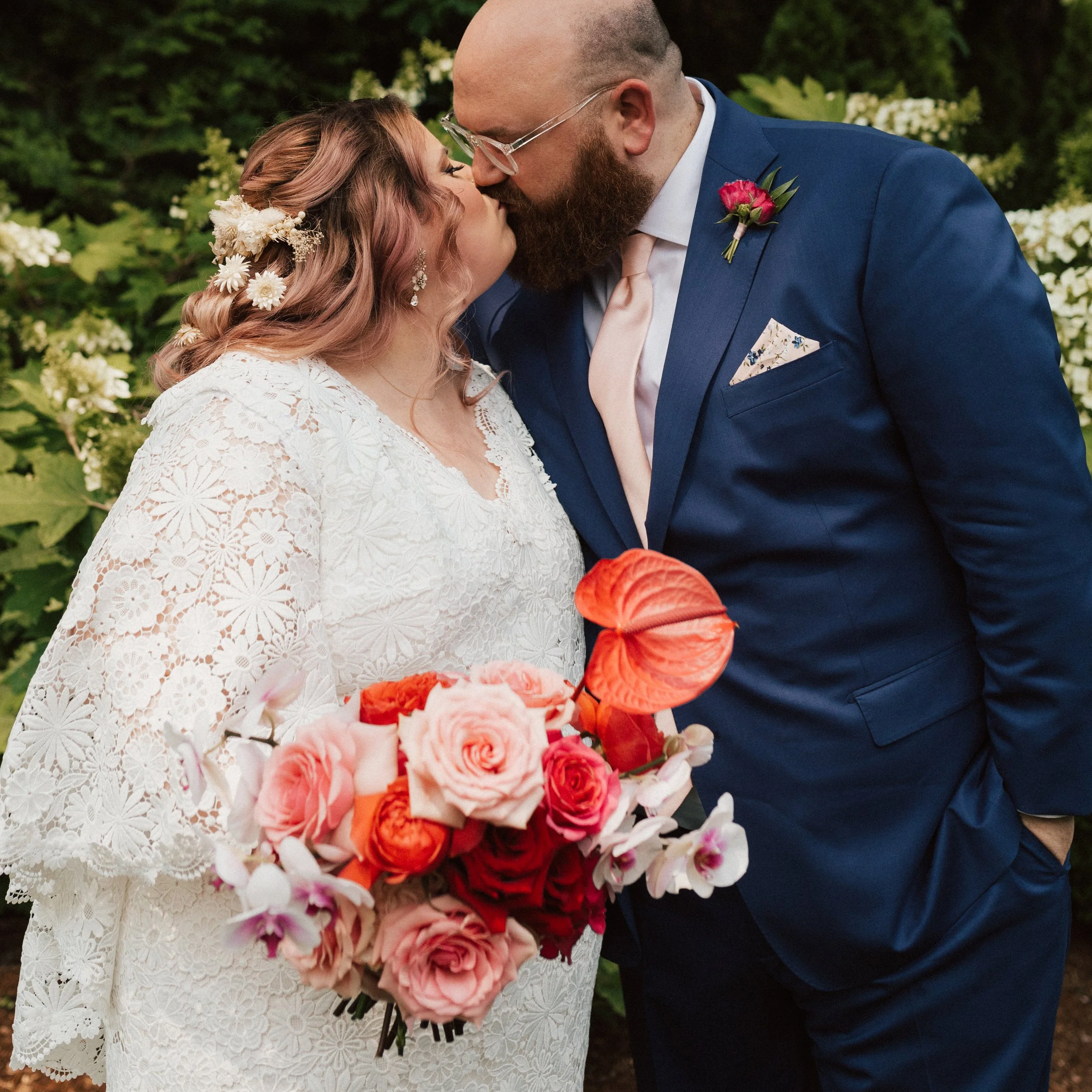 Colorful bridal bouquet featuring bold roses and sculptural anthuriums for a Connecticut garden wedding.