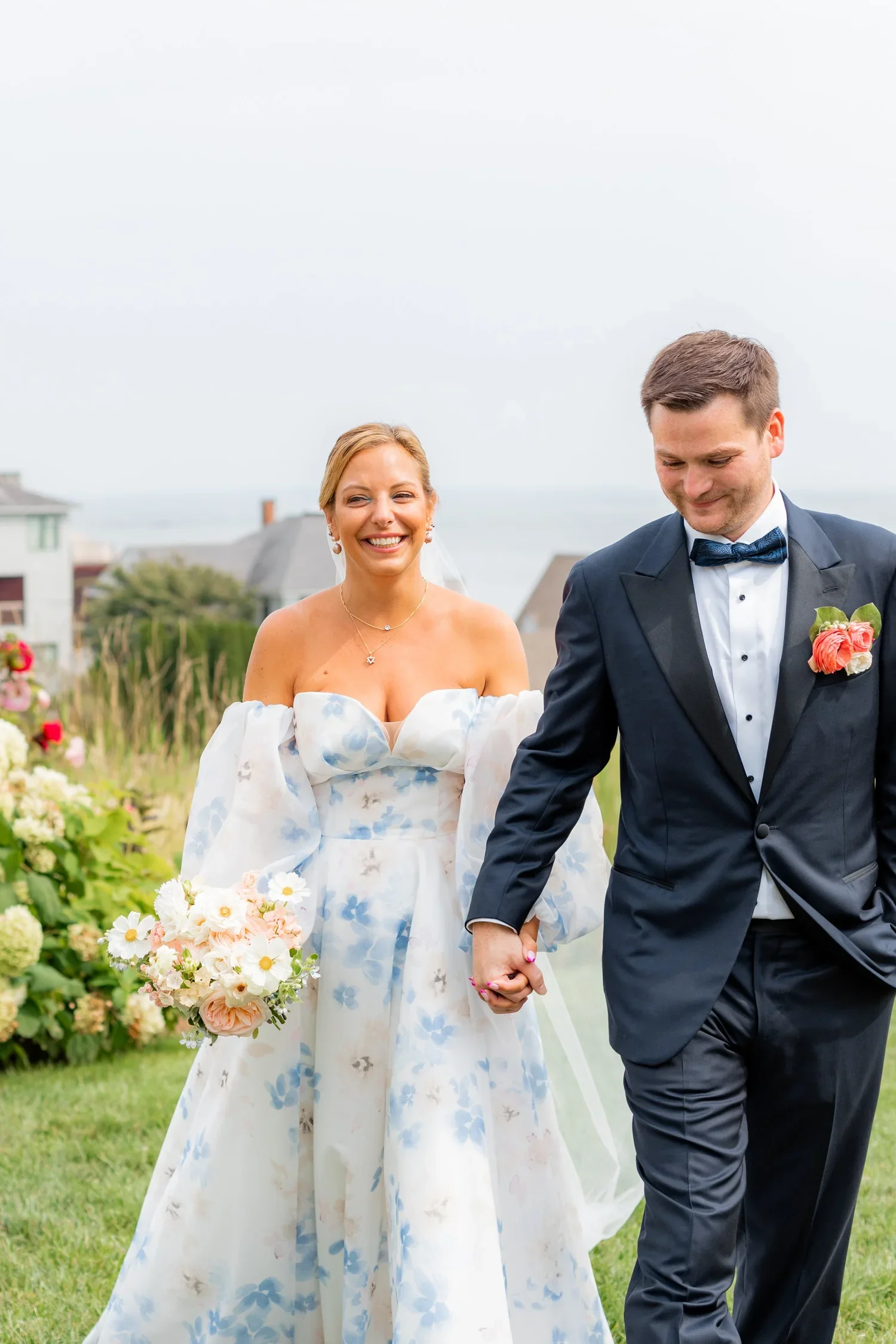 Bride and groom walk hand in hand with stunning airy cosmo bouquet at Waters Edge in Connecticut