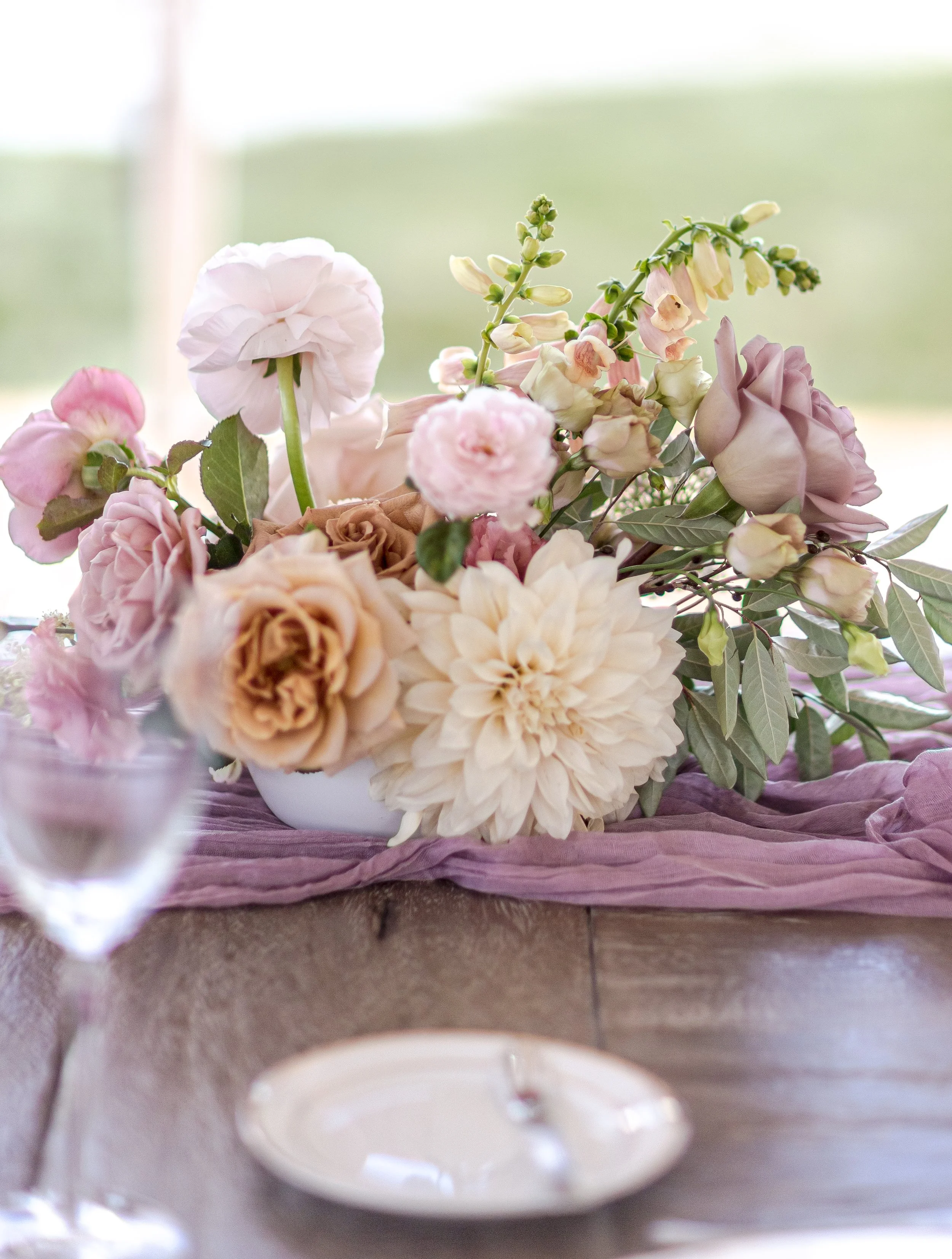 Garden-style floral centerpiece with dahlias and ranunculus