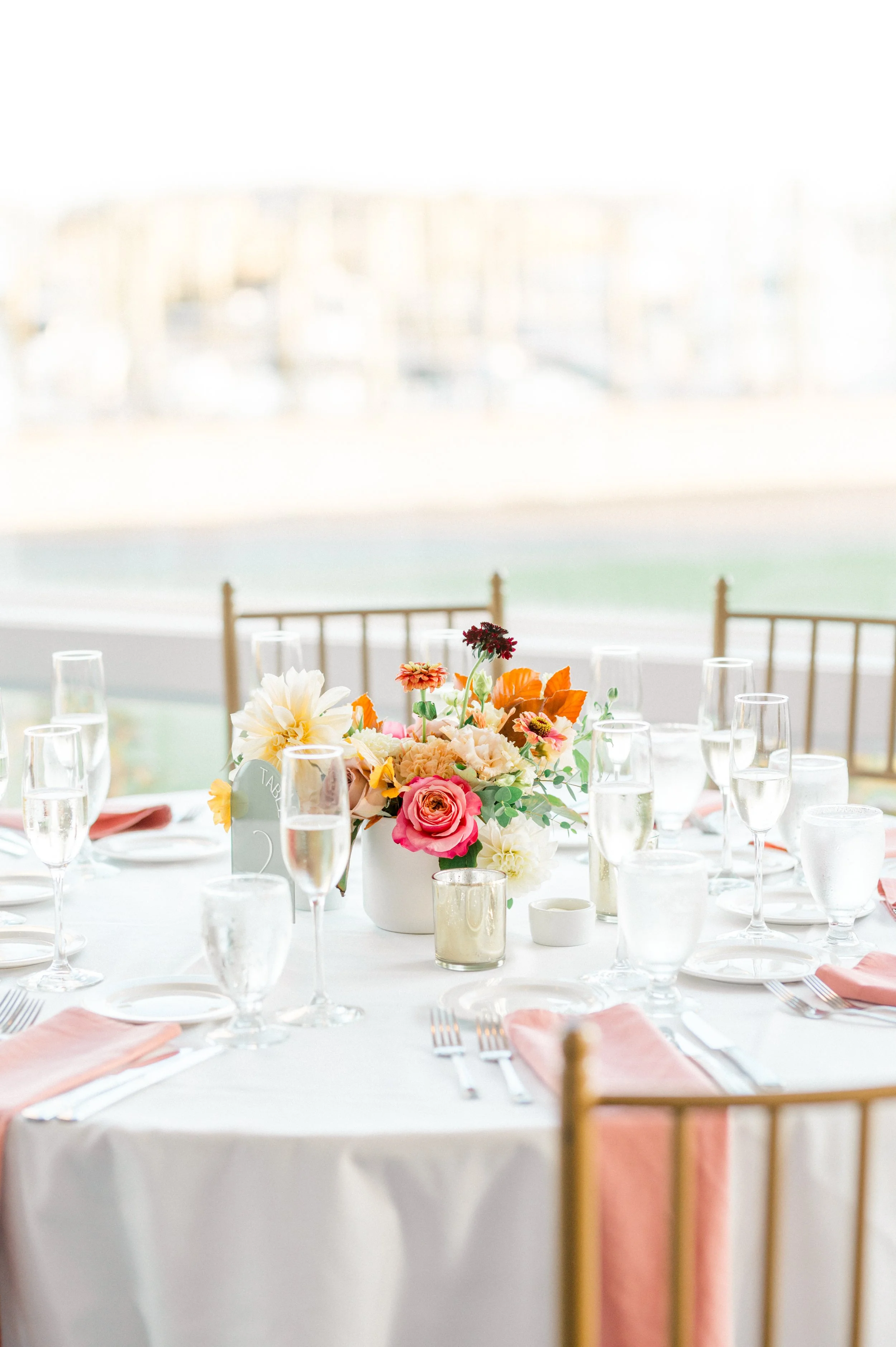 Bold and colorful fall centerpiece with dahlias, roses, and zinnias