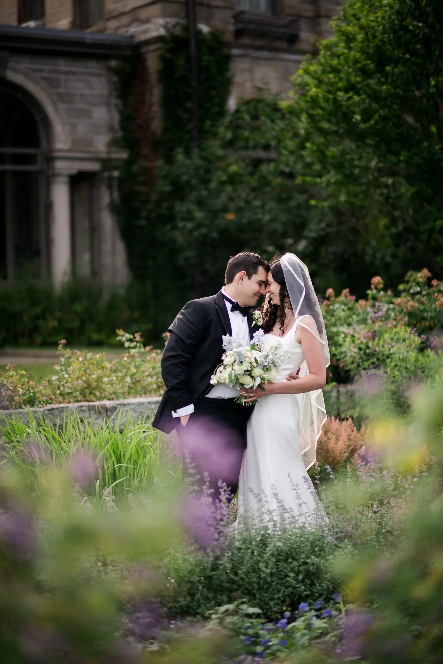 Bride and groom standing on the lawn overlooking Long Island Sound at Eolia Mansion.
