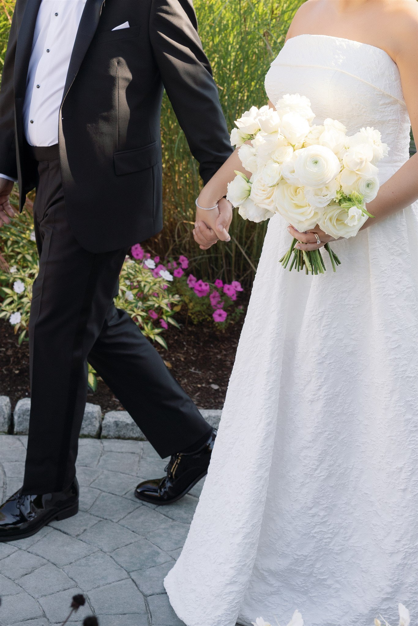Close-up of an all-white bridal bouquet glowing in natural summer light at Water’s Edge Resort.