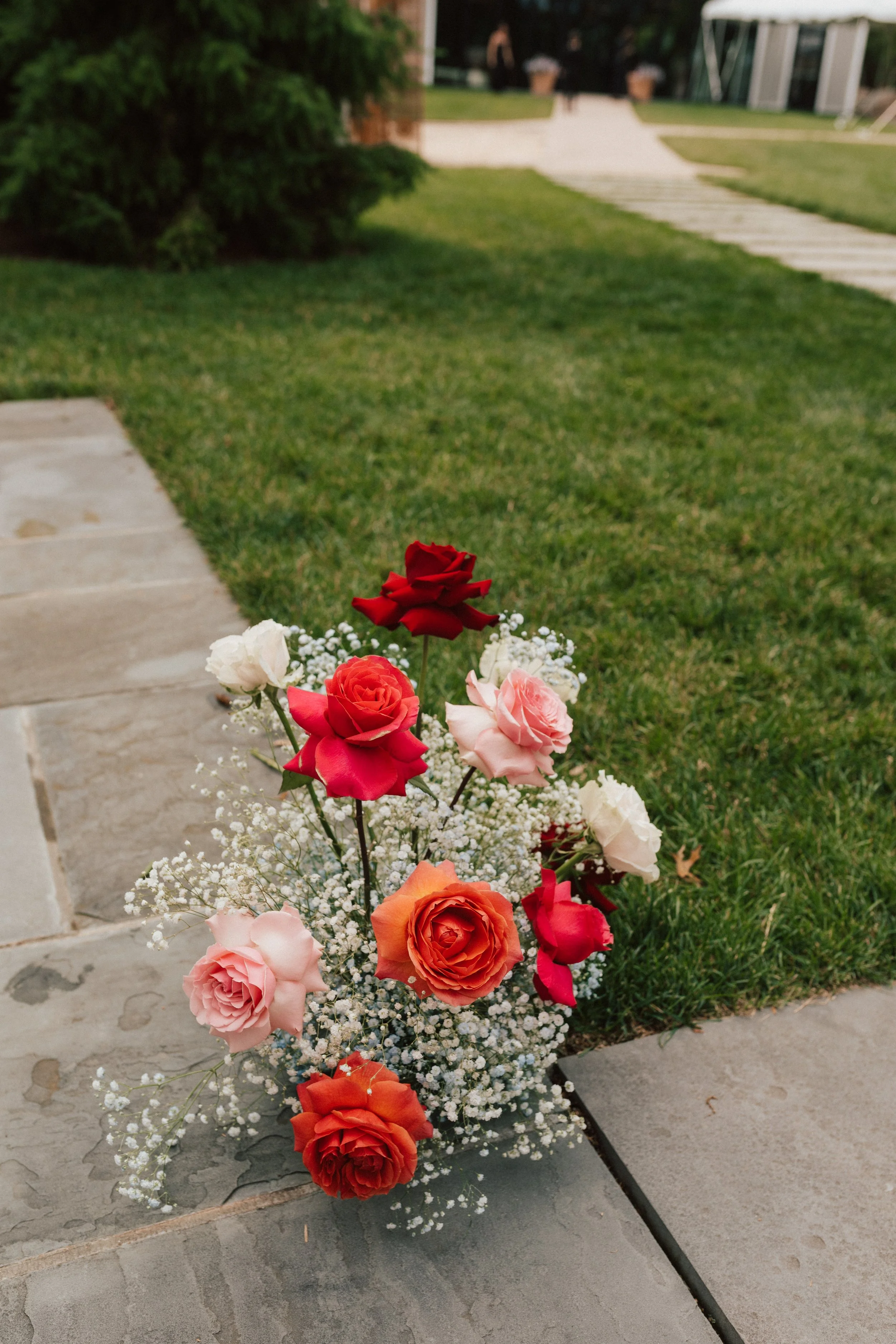 Architectural floral installation framing a wedding ceremony with bold, saturated florals and baby's breath.