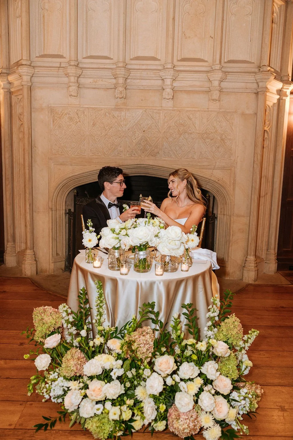Sweetheart table decorated with repurposed ceremony flowers and bridal bouquet