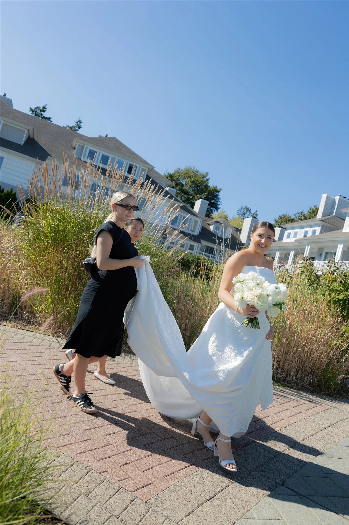 Detail of bridal styling and bouquet florals moving gently in the coastal breeze during a Connecticut summer wedding.