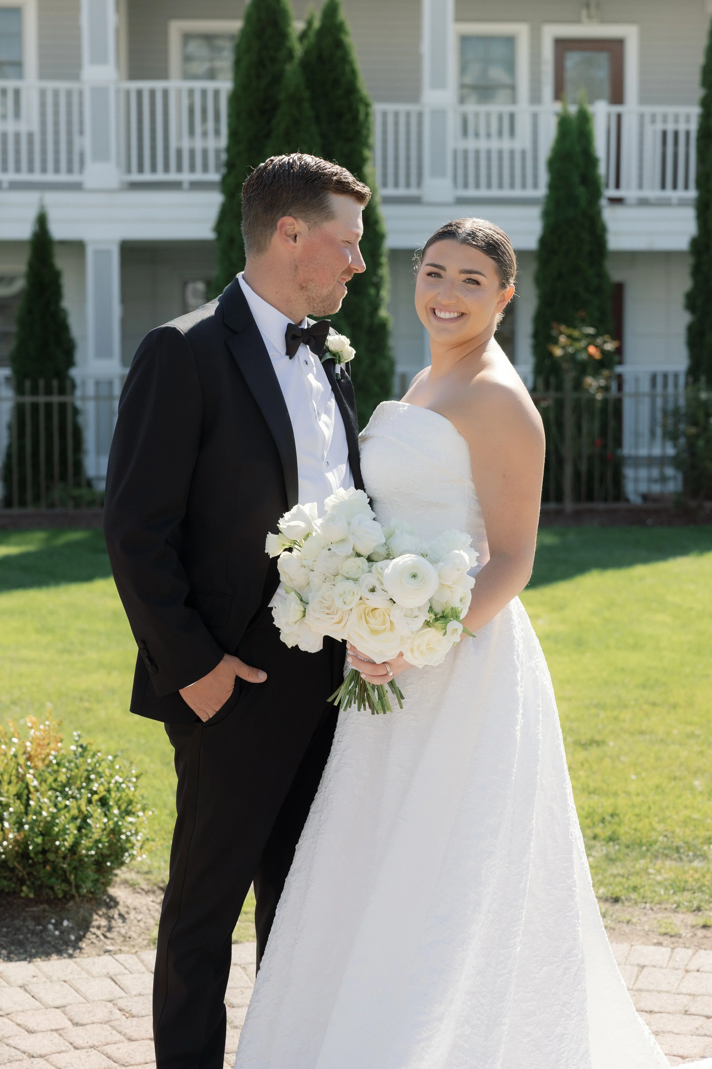 Stunning bride holding a lush all white bridal bouquet, posing for portaits.