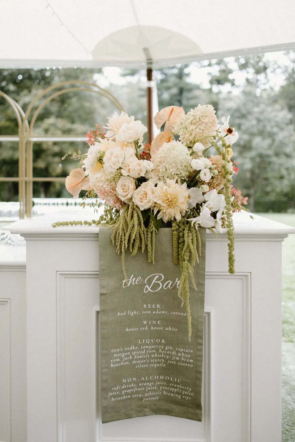 Soft blush and ivory garden-style wedding flowers arranged on a white ceremony column at Smith Farm Gardens.