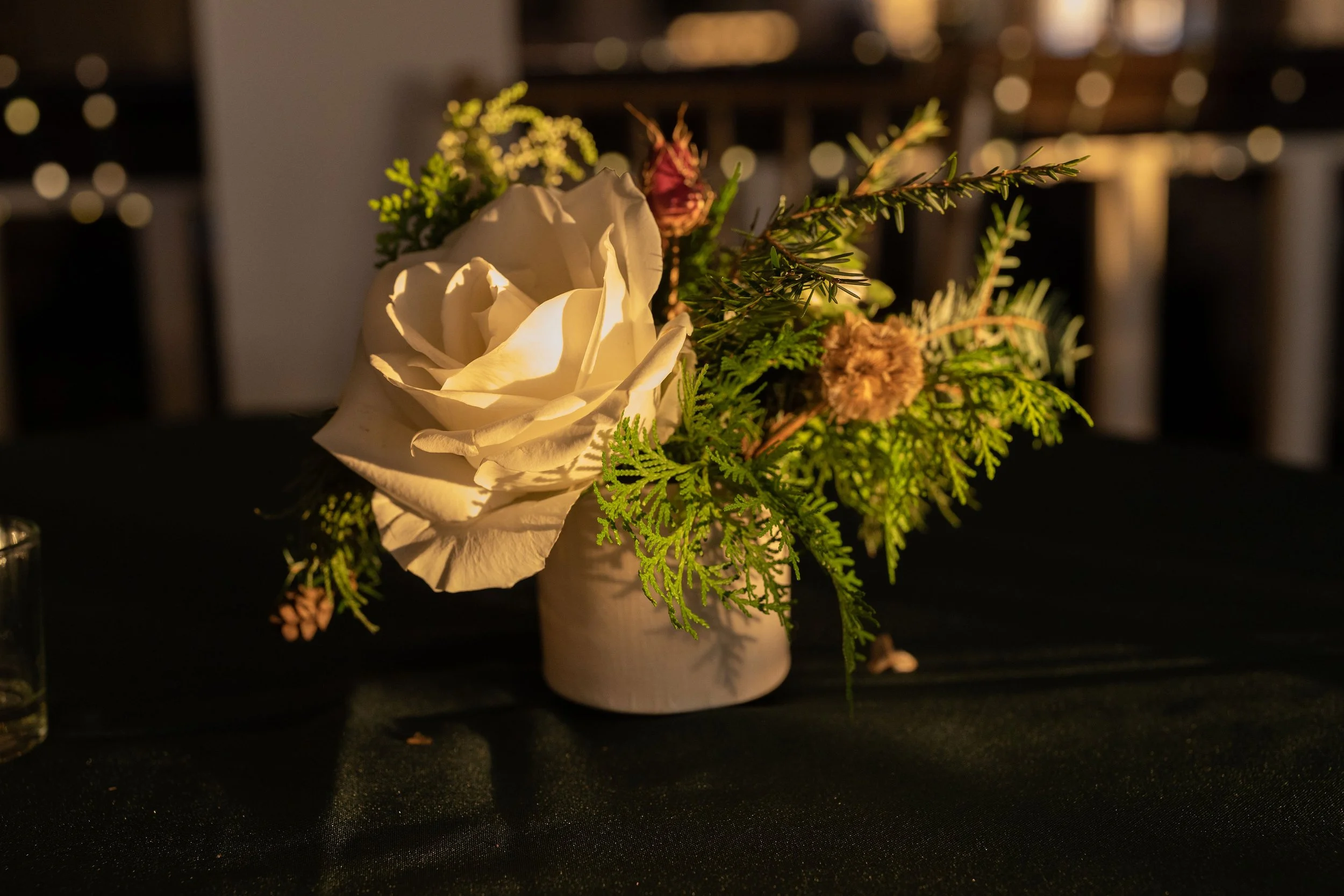 Close-up of airy white blooms and evergreen foliage in a winter floral arrangement