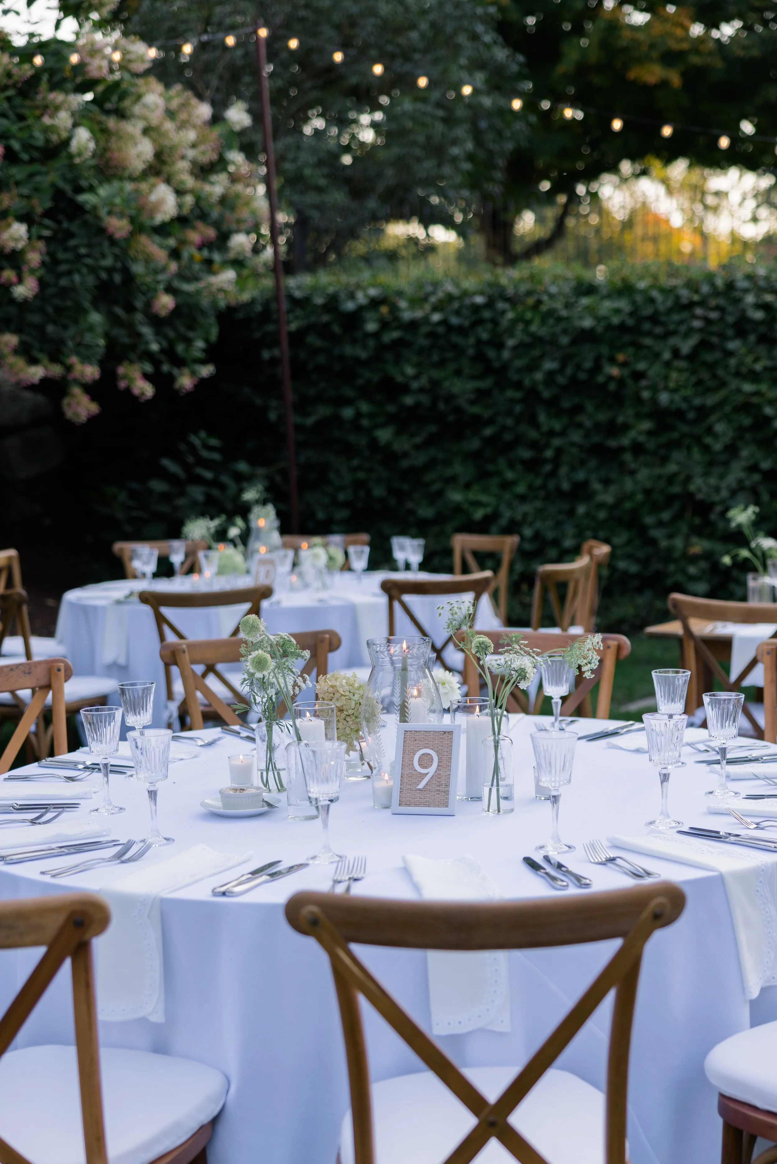 Wedding reception tablescape at Smith Farm Gardens with hurricanes and bud vase florals