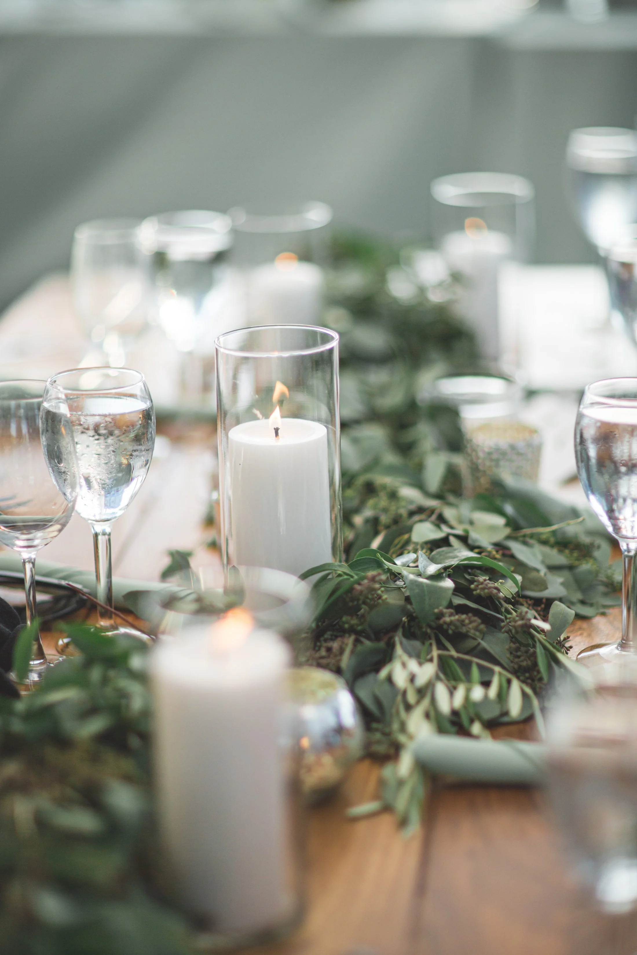 An eucalyptus garland runs the length of the table, alternating with tall candle clusters down a coastal Connecticut reception.