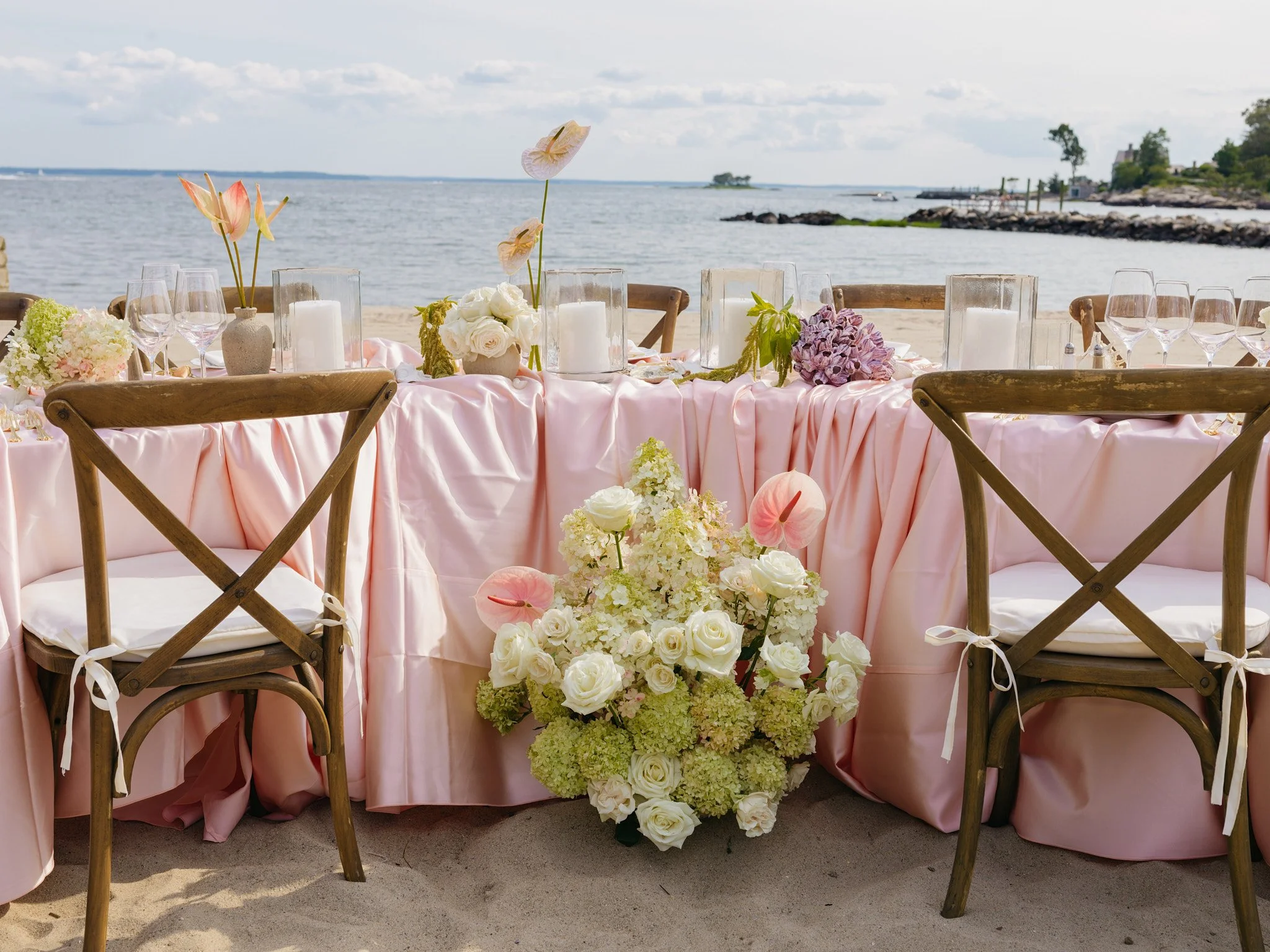 Blush satin table linen with hand-painted iridescent anthuriums from Haus of Stems, coastal wedding tablescape design