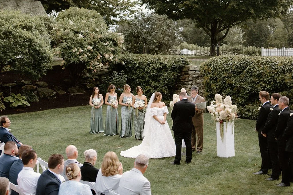 Wide view of wedding guests and the bridal party gathered for a romantic outdoor ceremony.