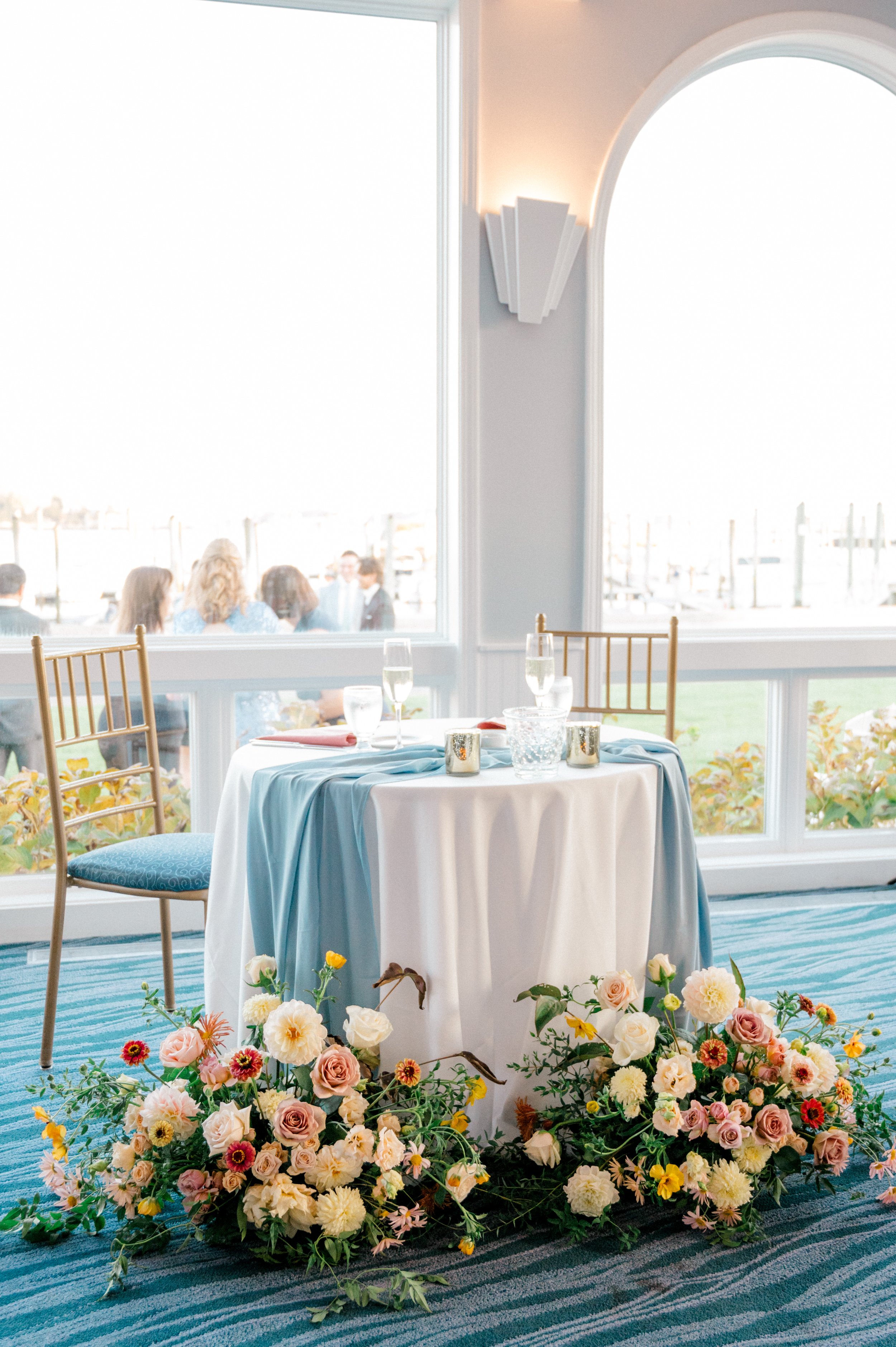 Sweetheart table with cascading fall florals in peach, blush, and burgundy