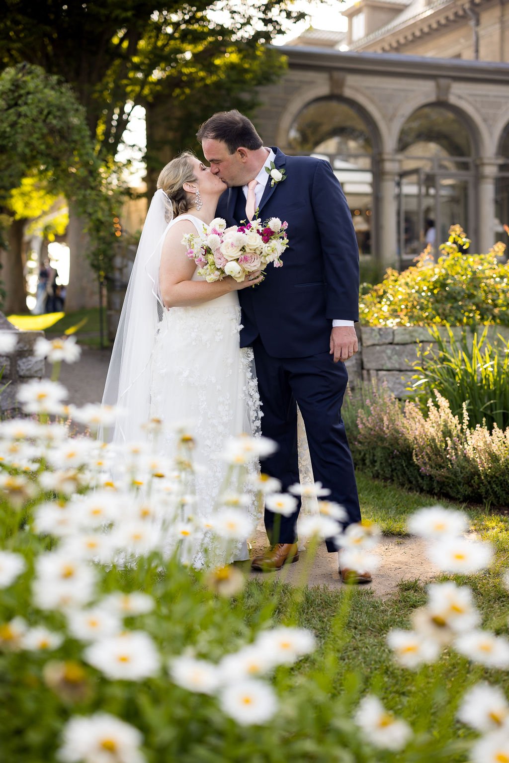 Bride and groom standing beneath the historic arched doorway at Eolia Mansion.