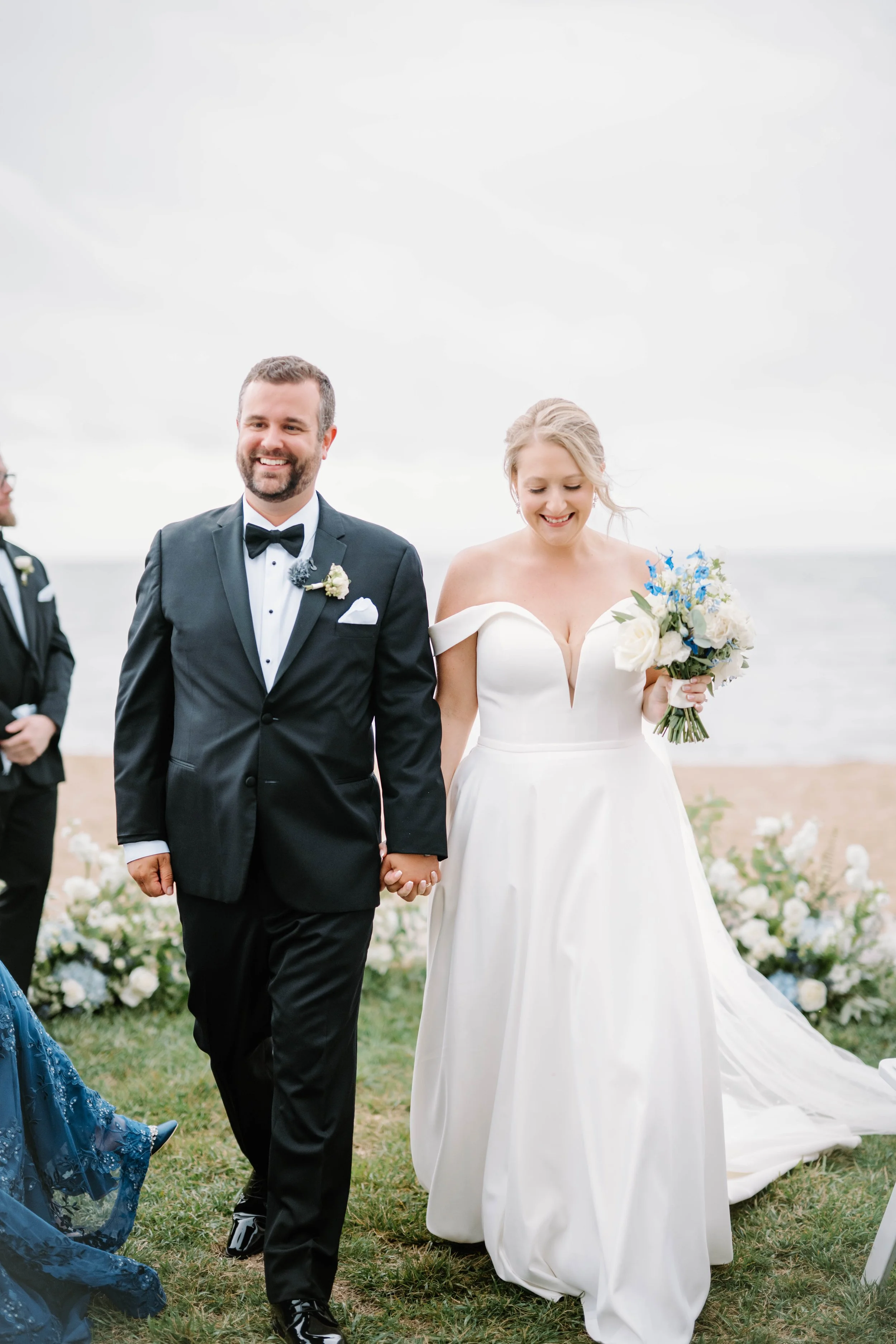 Outdoor ceremony on the grass overlooking Long Island Sound with romantic coastal floral design.