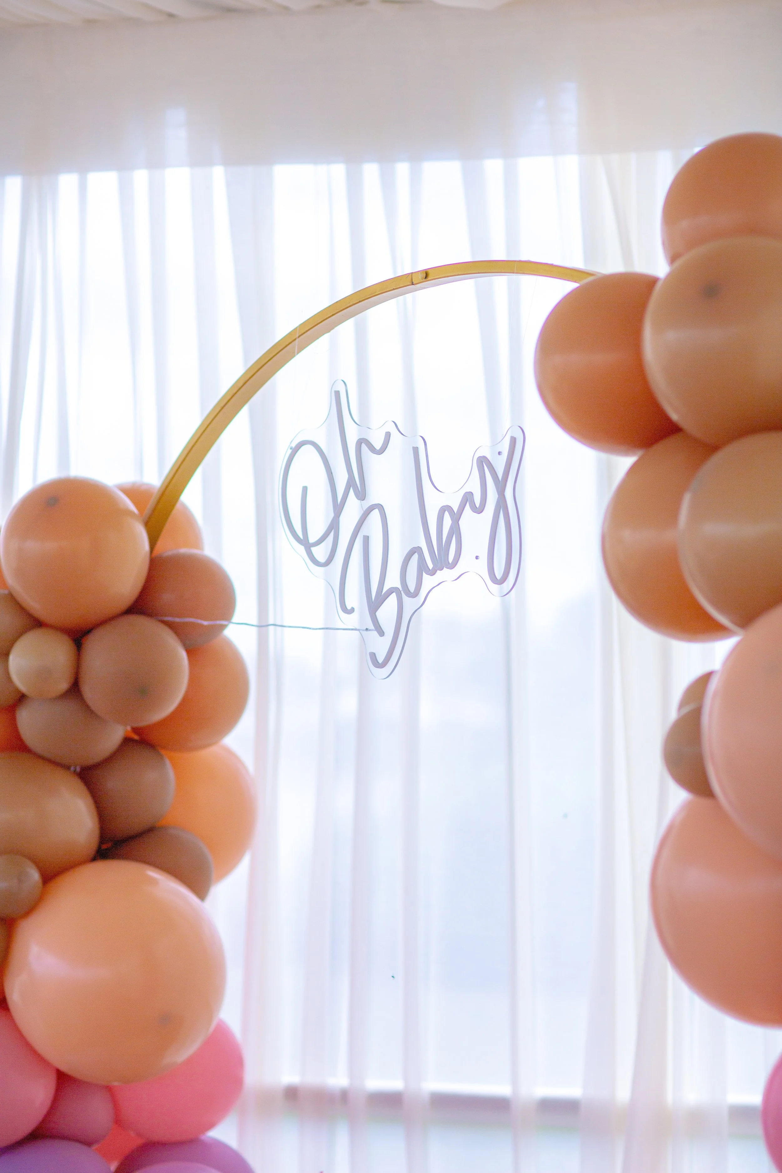 Pastel balloon arch installation inside a luxury baby shower tent
