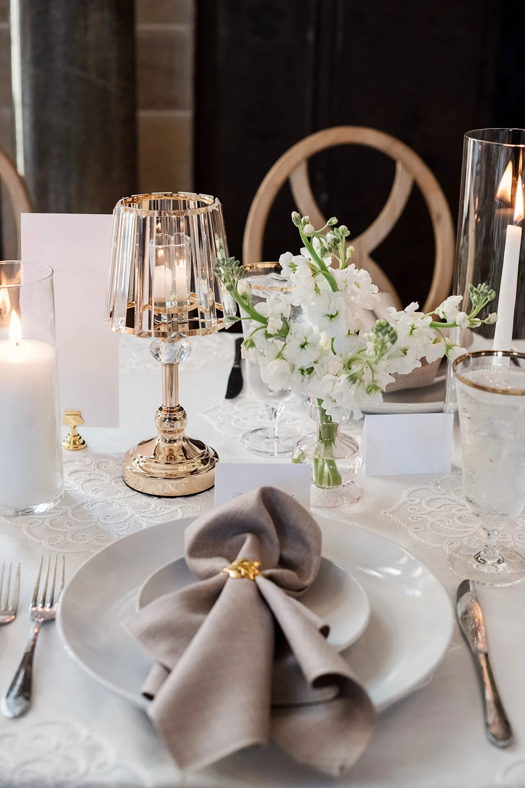 Long Branford House reception table with sculptural florals and mixed-height candle styling.
