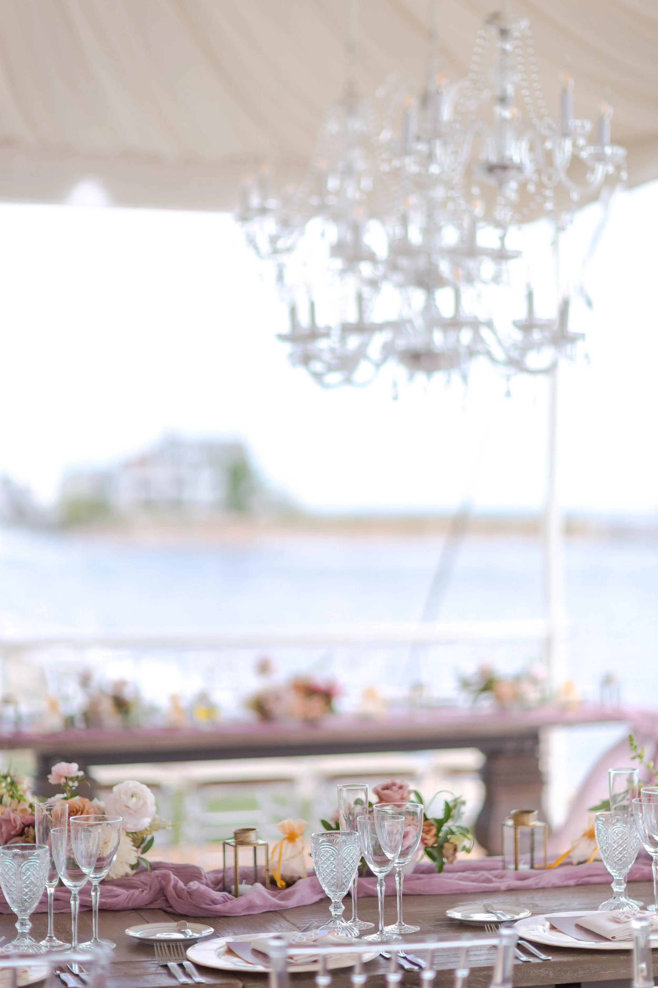 Crystal chandeliers and draped ceiling inside a luxury baby shower tent