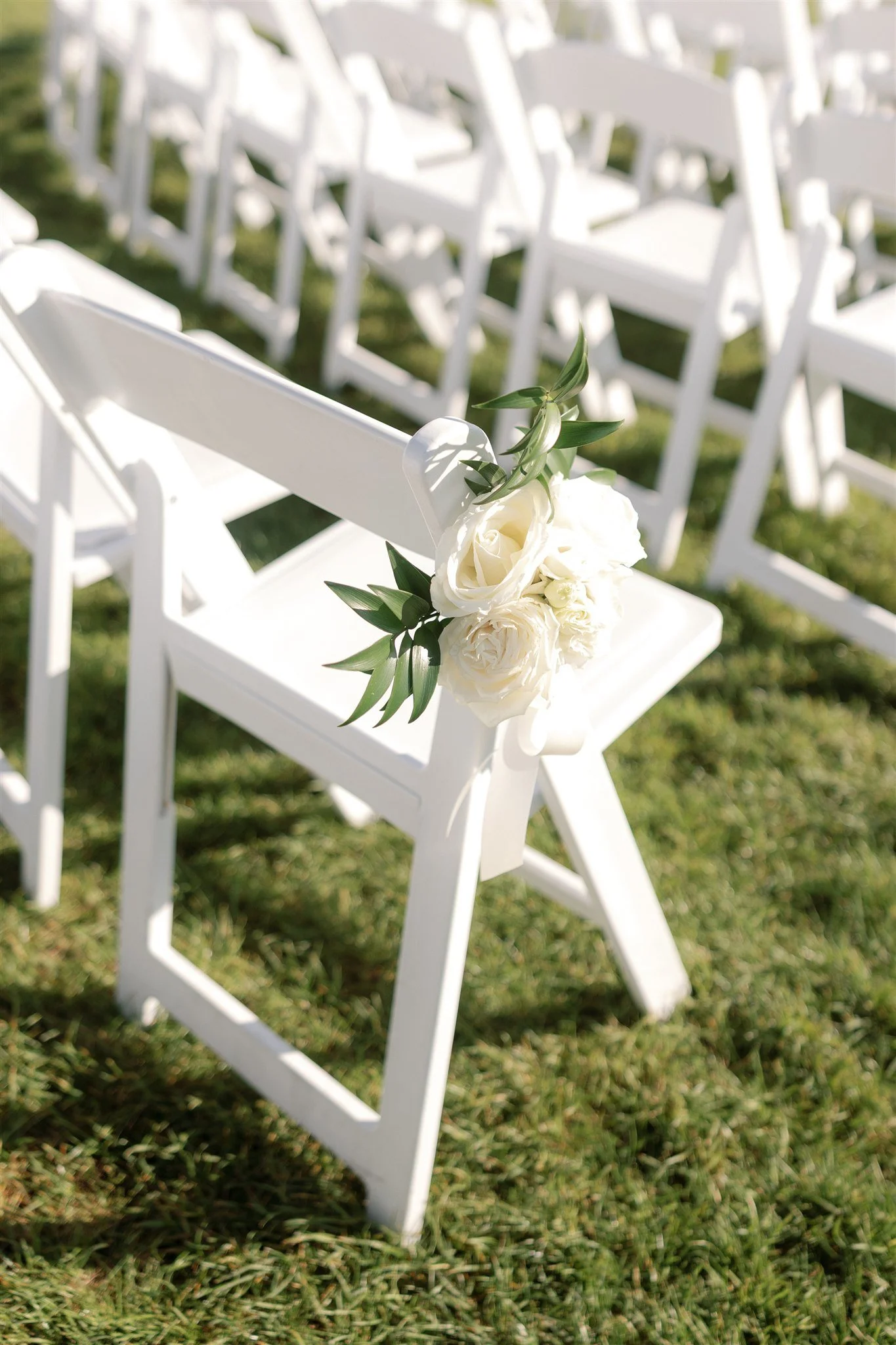 All-white floral arrangements with soft greenery adding movement to the ceremony installation.
